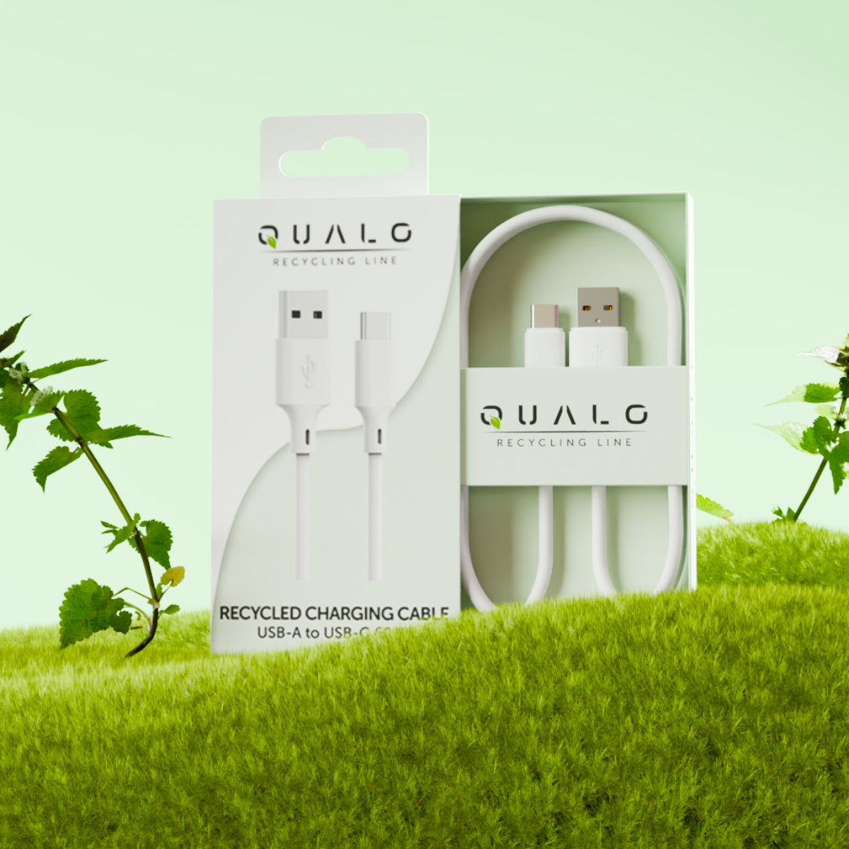 Białe pudełko z recyklingowym kablem ładującym w środku na zielonej, trawiastiej powierzchni. Pudełko ma logo: QUALG RECYCLING LINE.