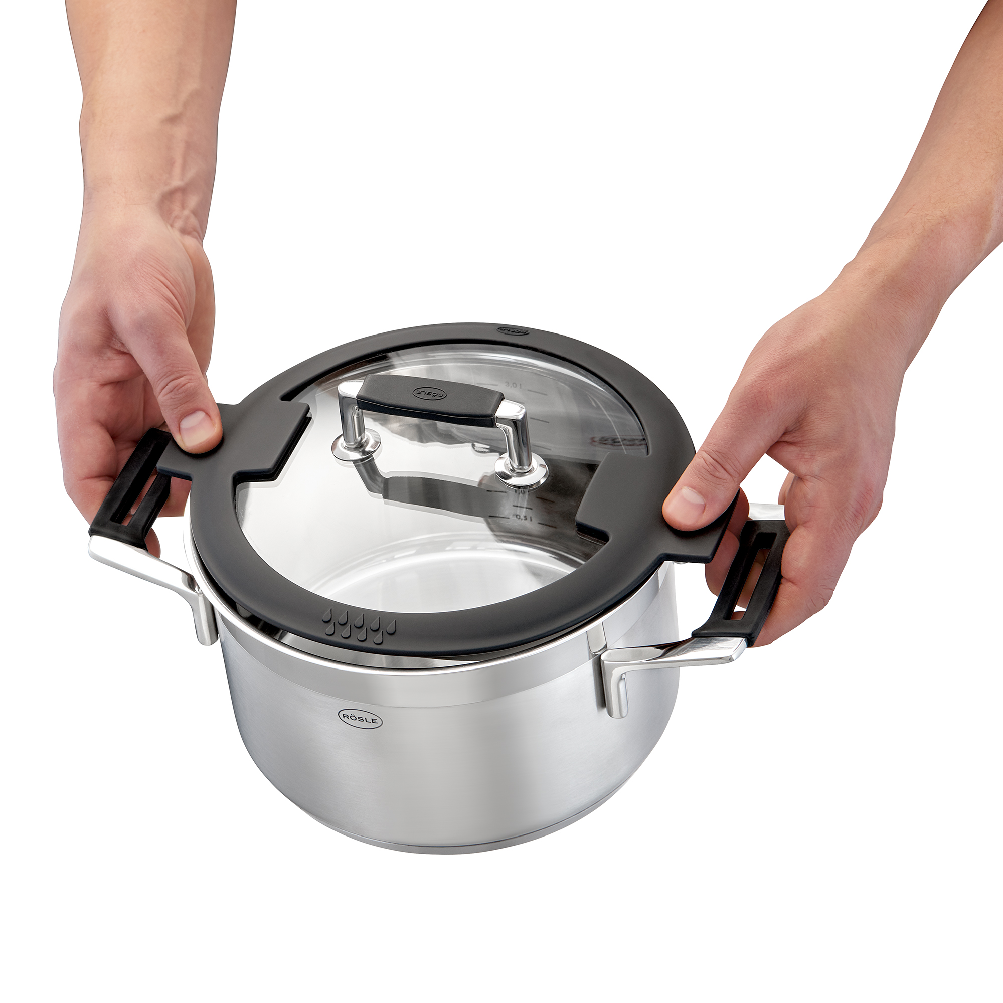 Mains tenant le couvercle d'une casserole au-dessus d'une casserole. Fond blanc.