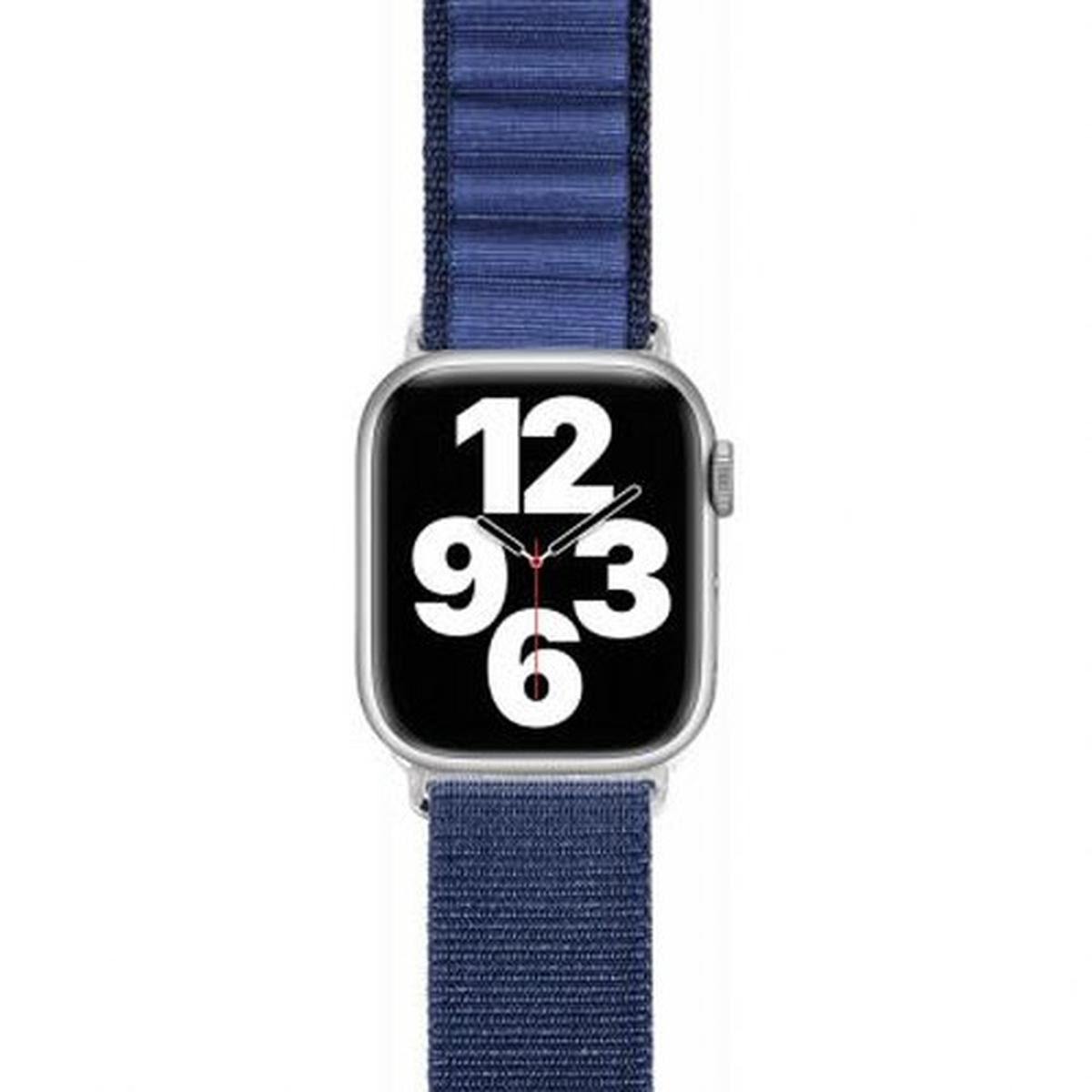 Apple Watch con cinturino in tessuto blu. Quadrante mostra i numeri 12, 9, 3 e 6.