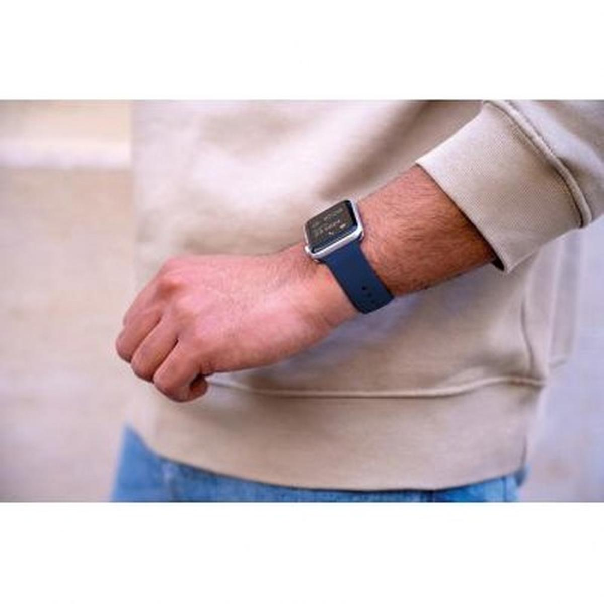 Persona che indossa un orologio blu con cinturino blu, su sfondo bianco.