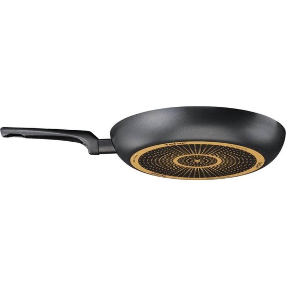Black frying pan with a long handle. The bottom has a gold design.