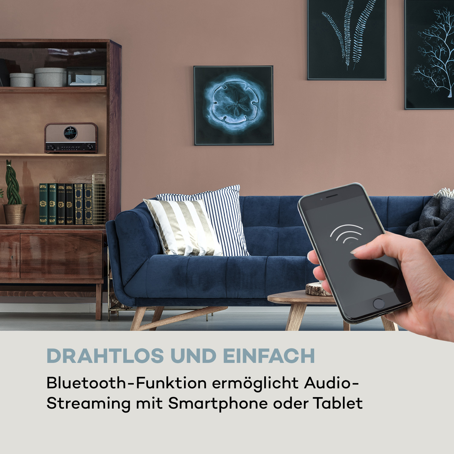 Hand hält Telefon mit Signal-Icon, blaue Couch, Gemälde, Bücherregal.