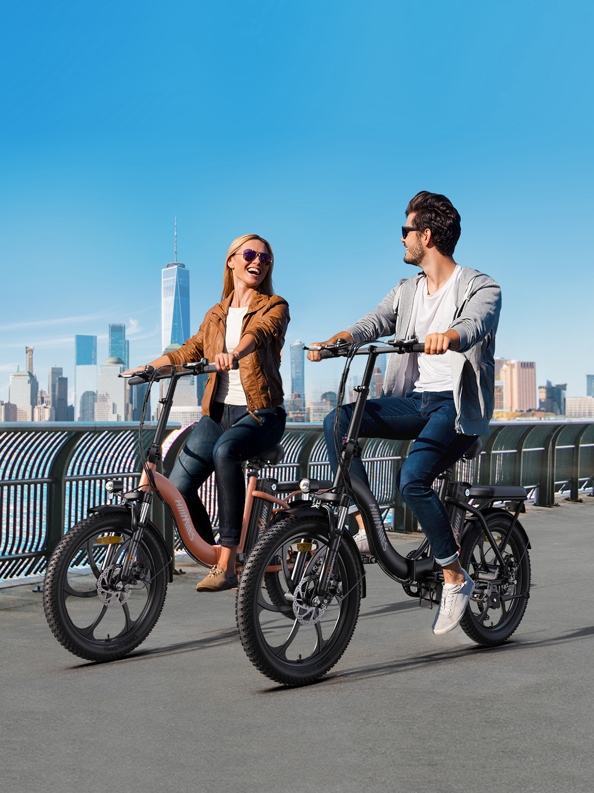 Dos personas montan bicicletas eléctricas negras y rosas en un día soleado. Skyline de la ciudad al fondo.
