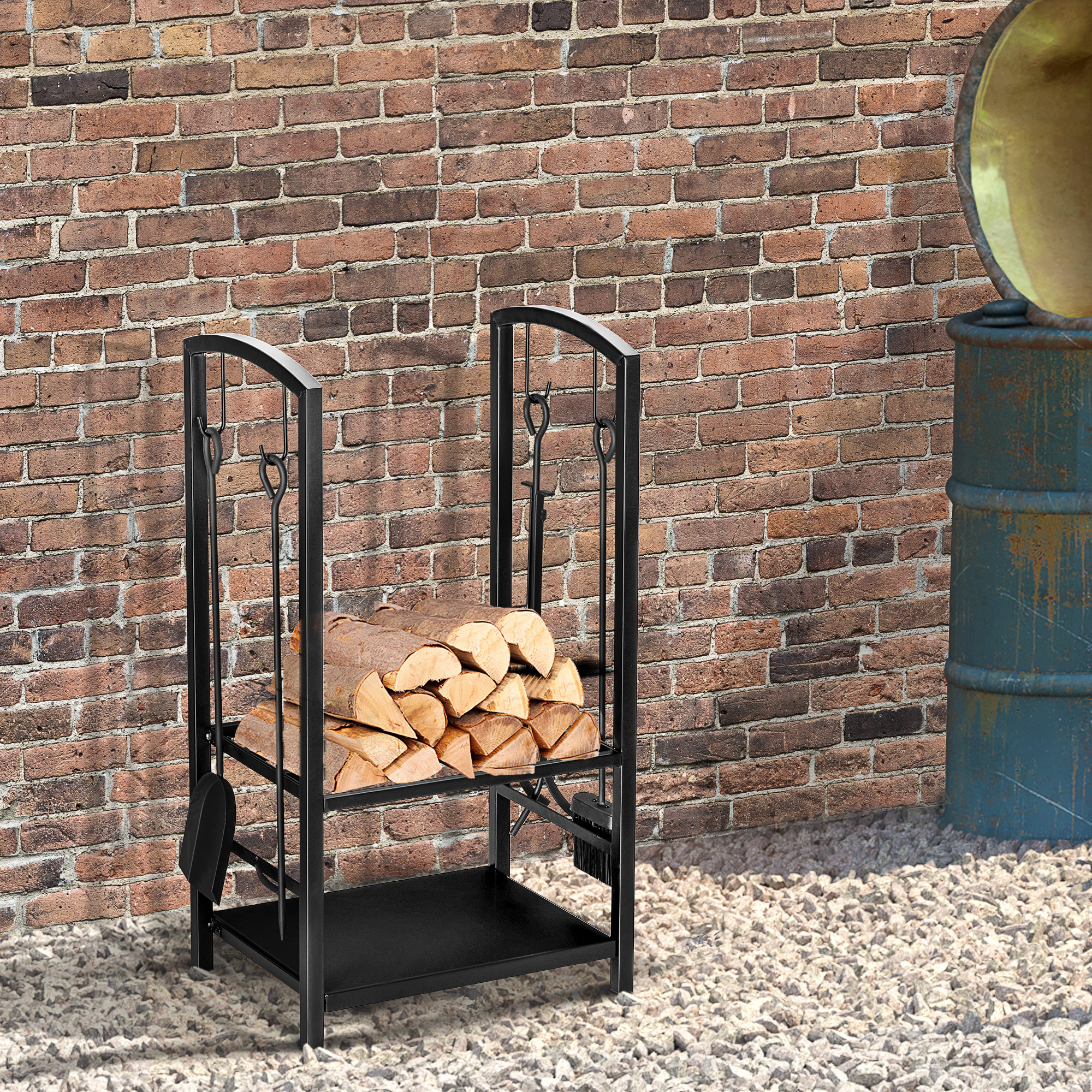 Schwarzes Metall-Brennholzregal mit Holzscheiten. Hintergrund ist eine Ziegelmauer, kleine Kieselsteine und ein Fass.