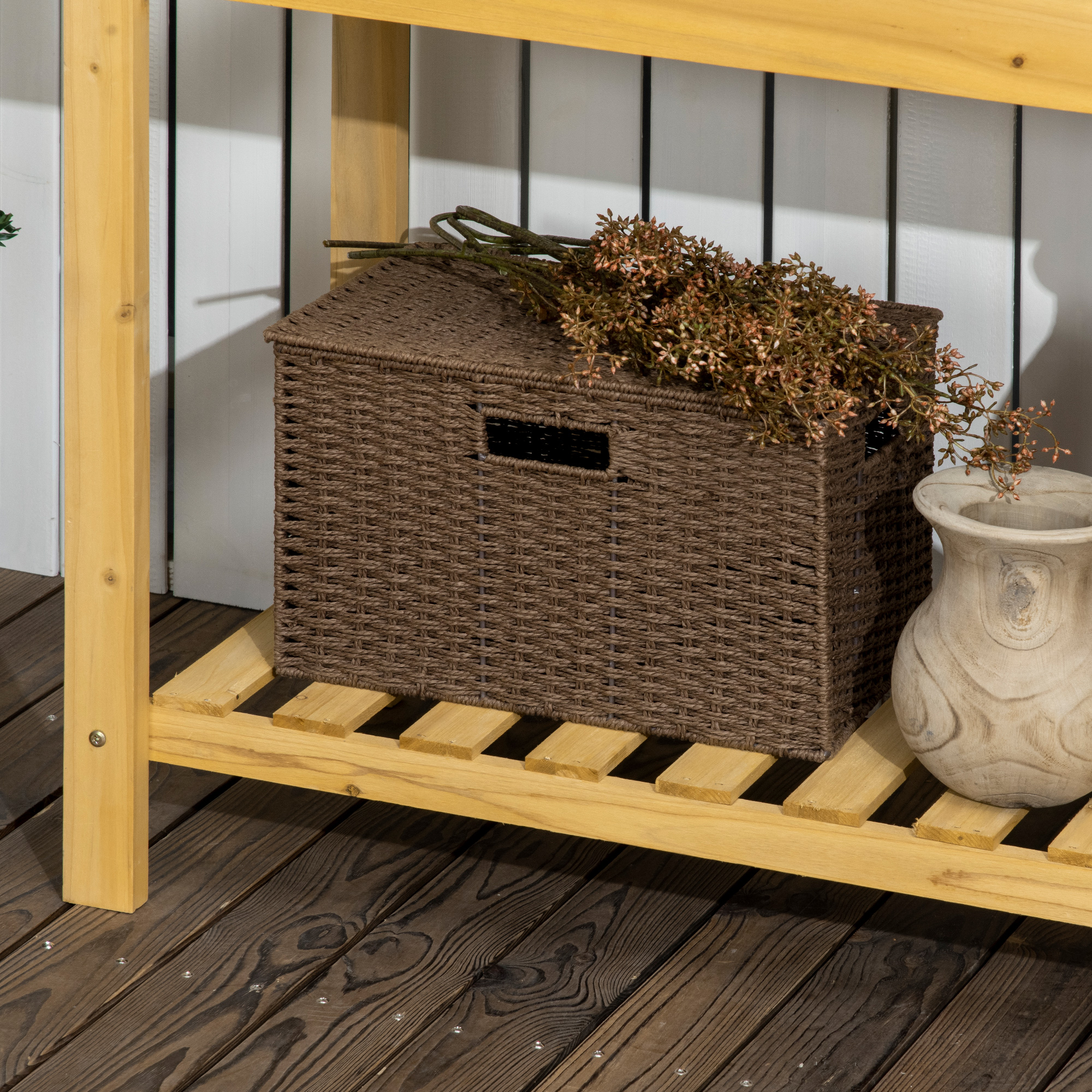 Holzregal mit braunem Korb und Vase. Trockenblumen liegen über dem Korb.