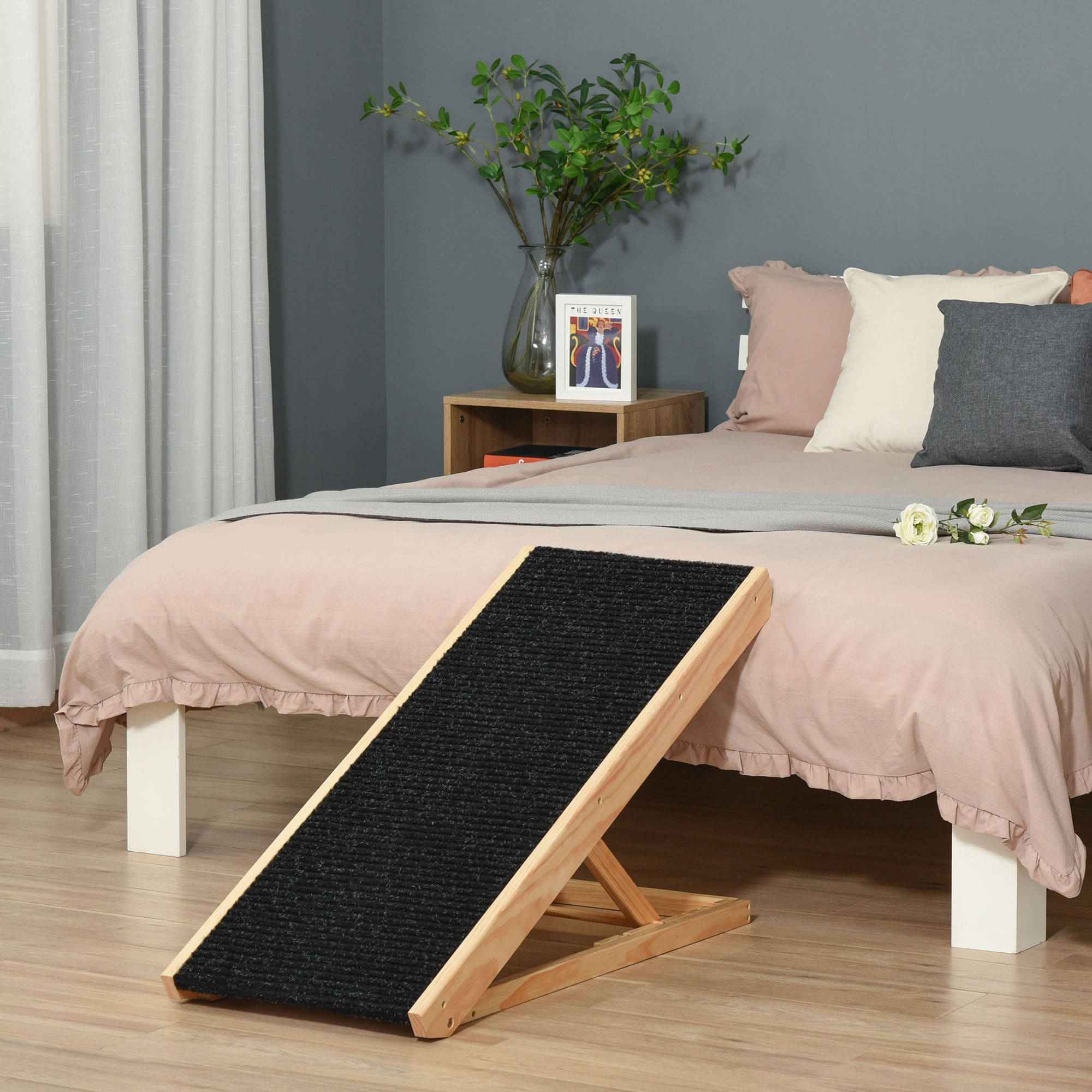 Hölzerne Haustierrampe auf einem Bett mit Kissen und einer Blume.