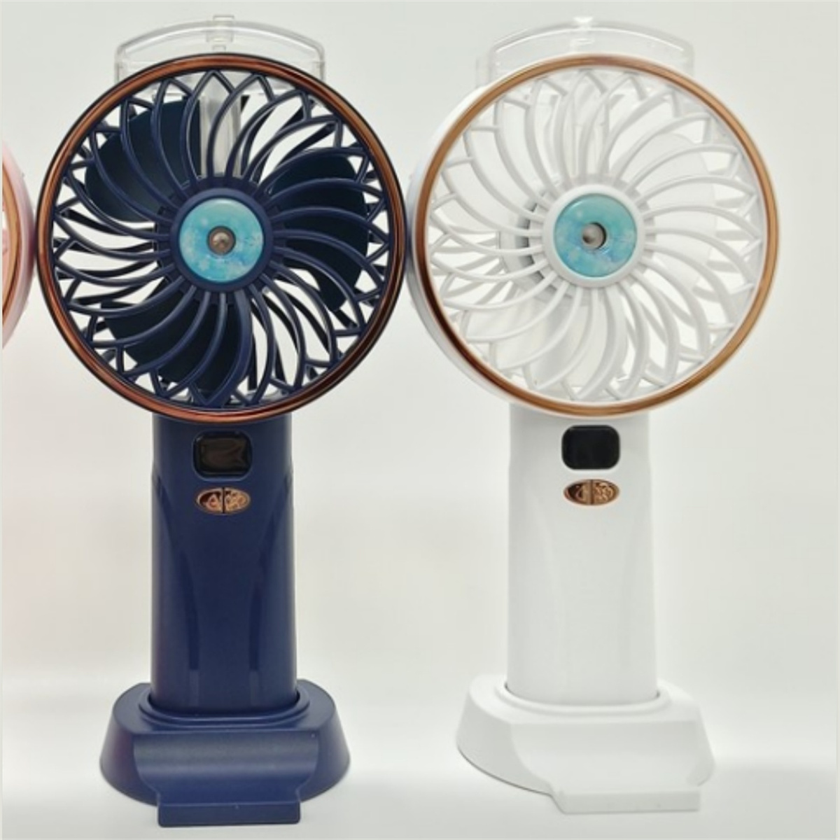 Zwei tragbare Ventilatoren, einer blau und einer weiß, mit goldenen Akzenten. Beide haben Lüfterblätter und Ständer.