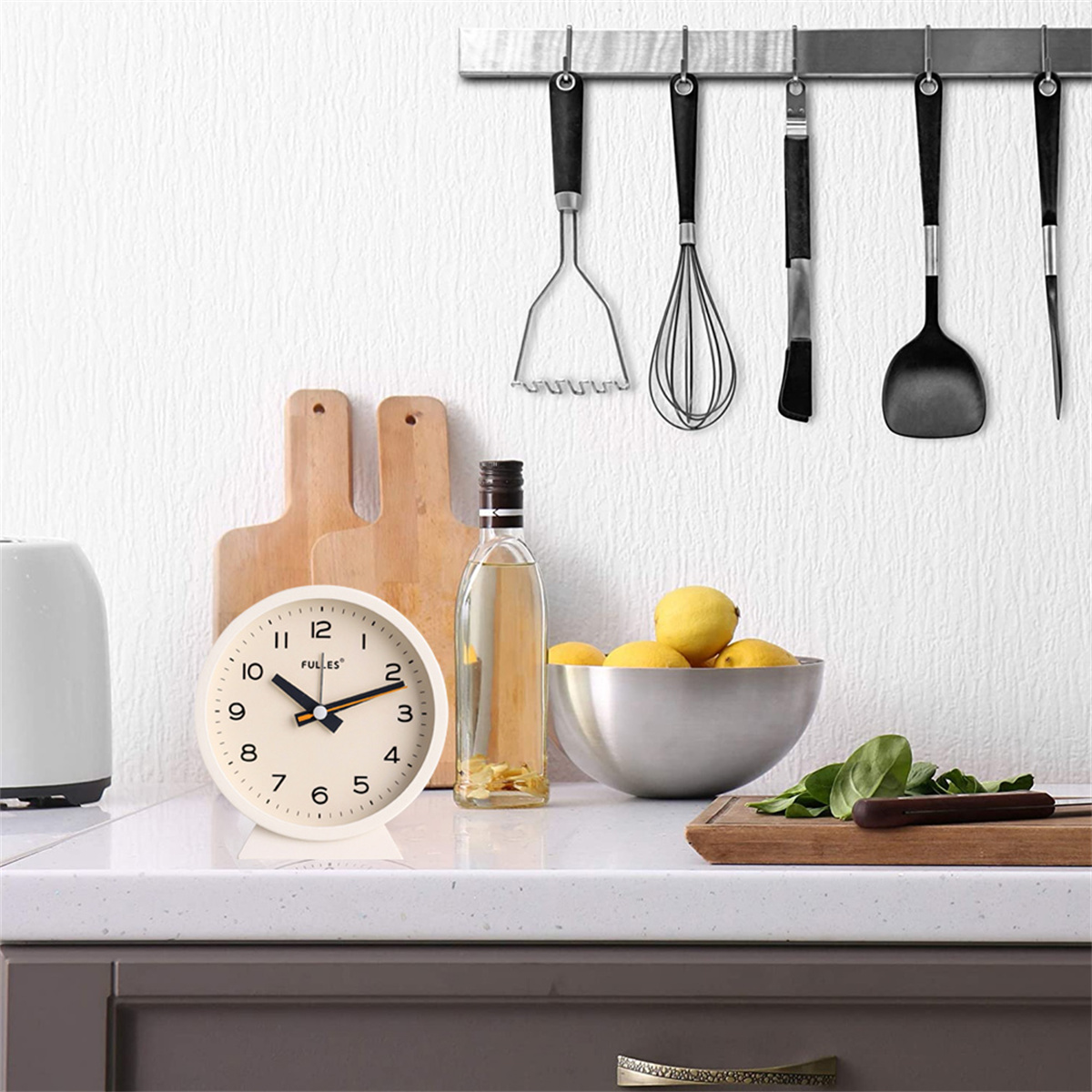 Eine Küchenzeile mit Uhr, Schneidebrettern, Zitronen und Utensilien, die an der Wand hängen.