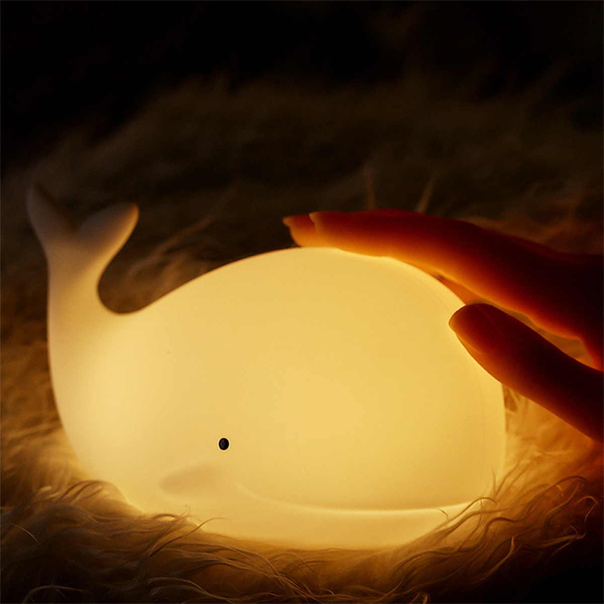 Weißes walförmiges Leuchten. Eine Hand berührt die Lampe. Dunkler Hintergrund.