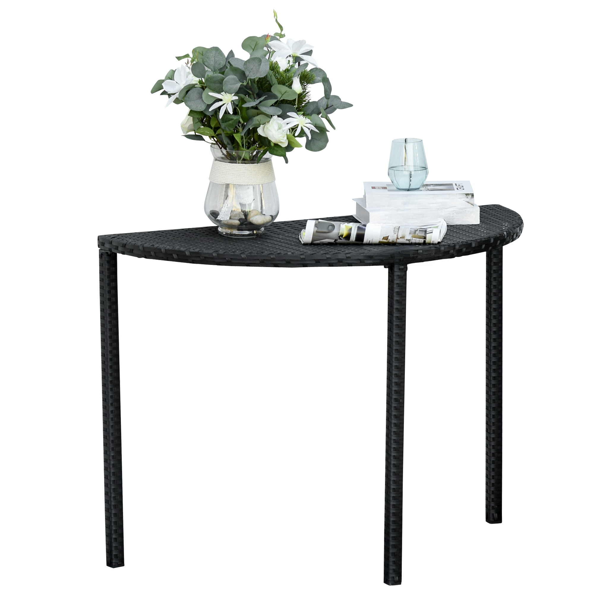 Ein schwarzer Rattan-Halbkreis-Tisch mit Blumen und einem Glas Wasser darauf.