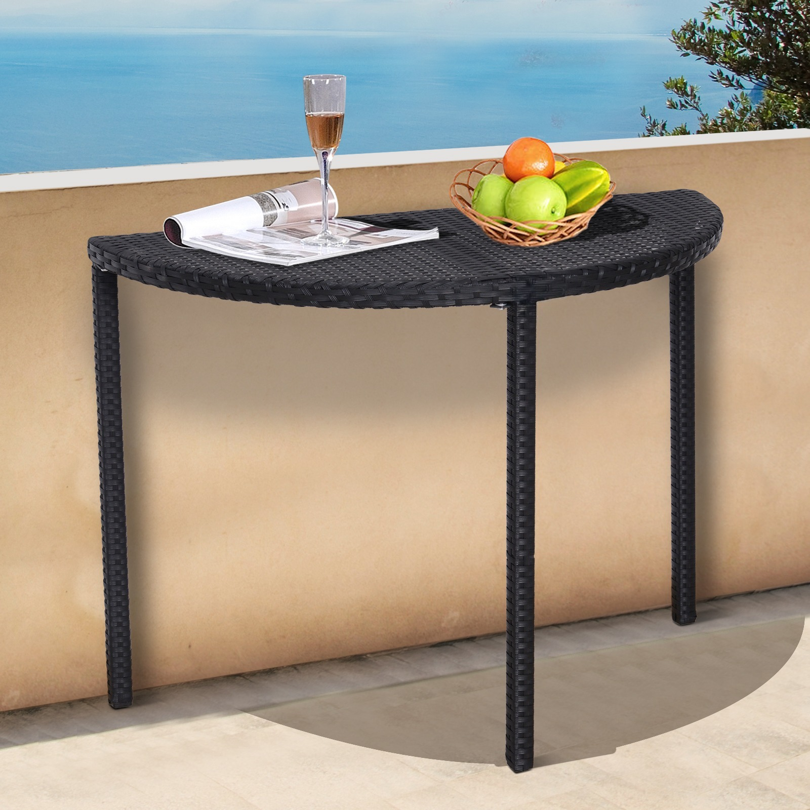 Ein schwarzer Rattan-Halbkreis-Tisch auf einem Balkon mit Wein und Obst.