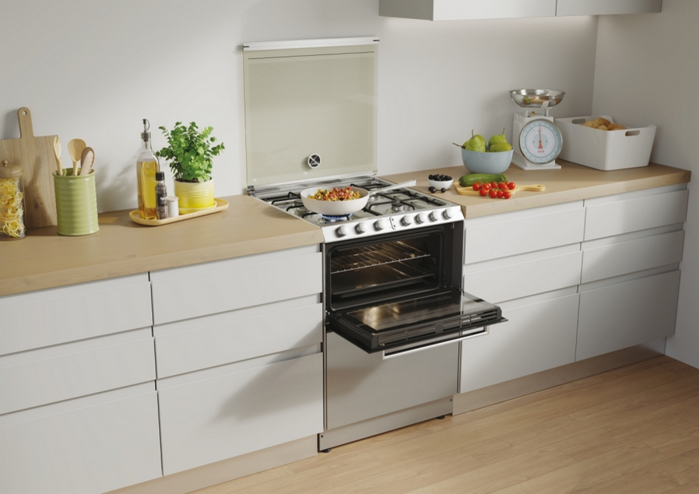 Scena di cucina con fornello, forno aperto e ripiani con generi alimentari.
