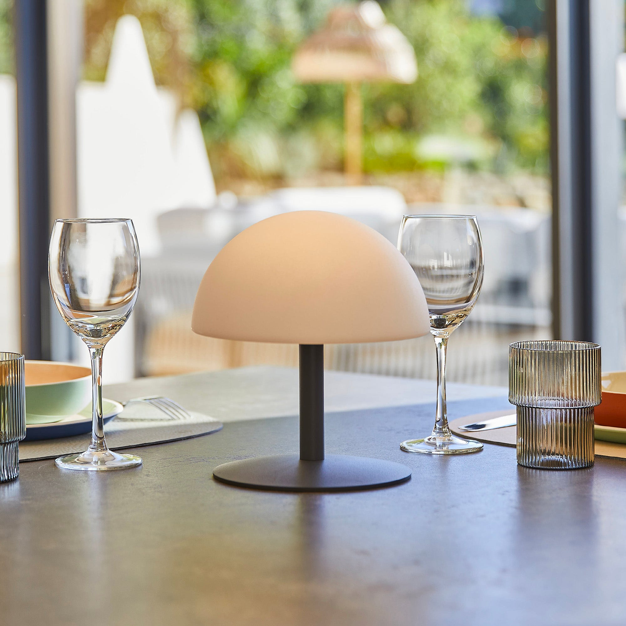 Ein Tisch mit zwei Gläsern und einer kuppelförmigen Lampe.