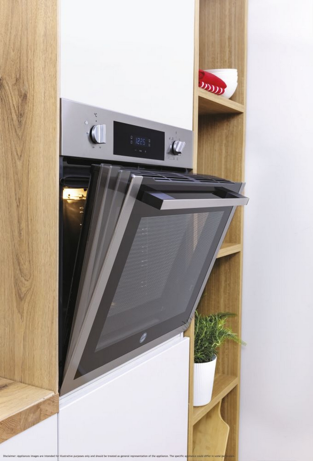 Forno a incasso con porta aperta in un mobile di legno. Visibili una piccola pianta e mensole con ciotole.