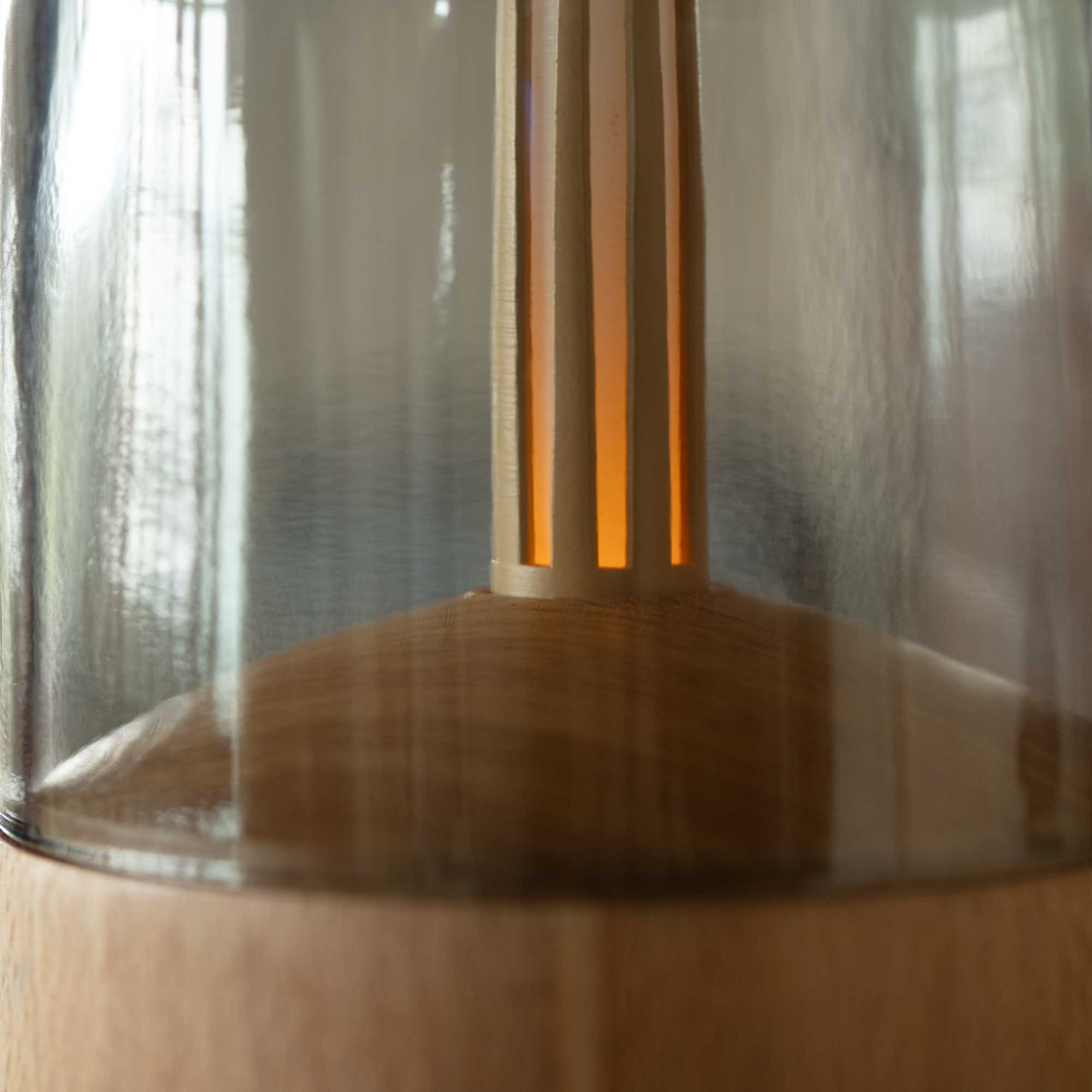 Close-up of a transparent essential oil diffuser with a wooden base, and information.