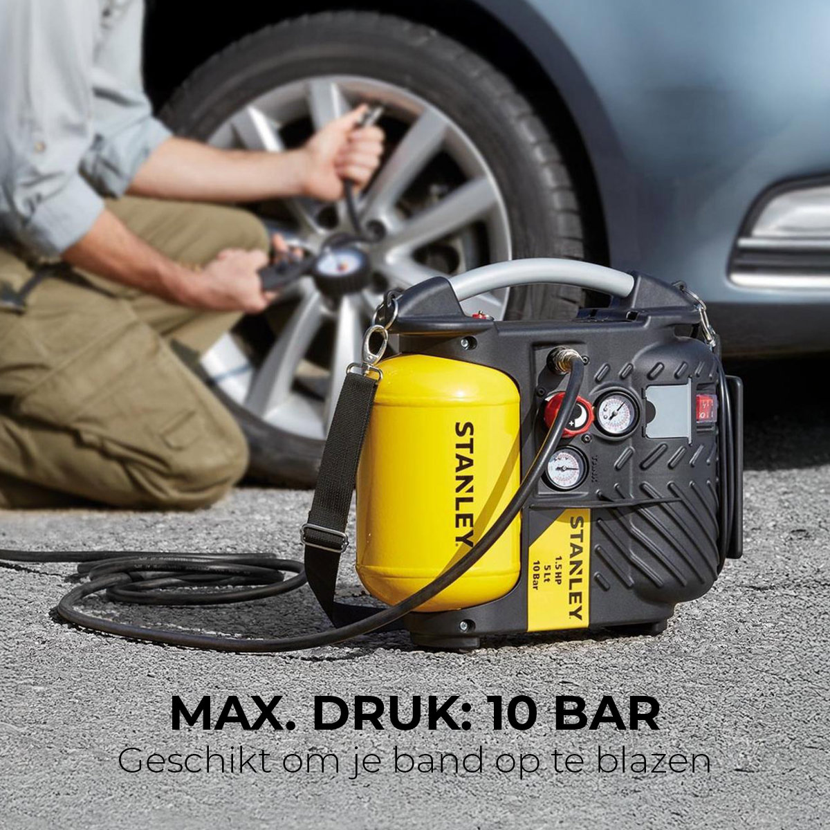 Mężczyzna pompuje oponę w pobliżu samochodu. Tekst: MAX. DRUK: 10 BAR.