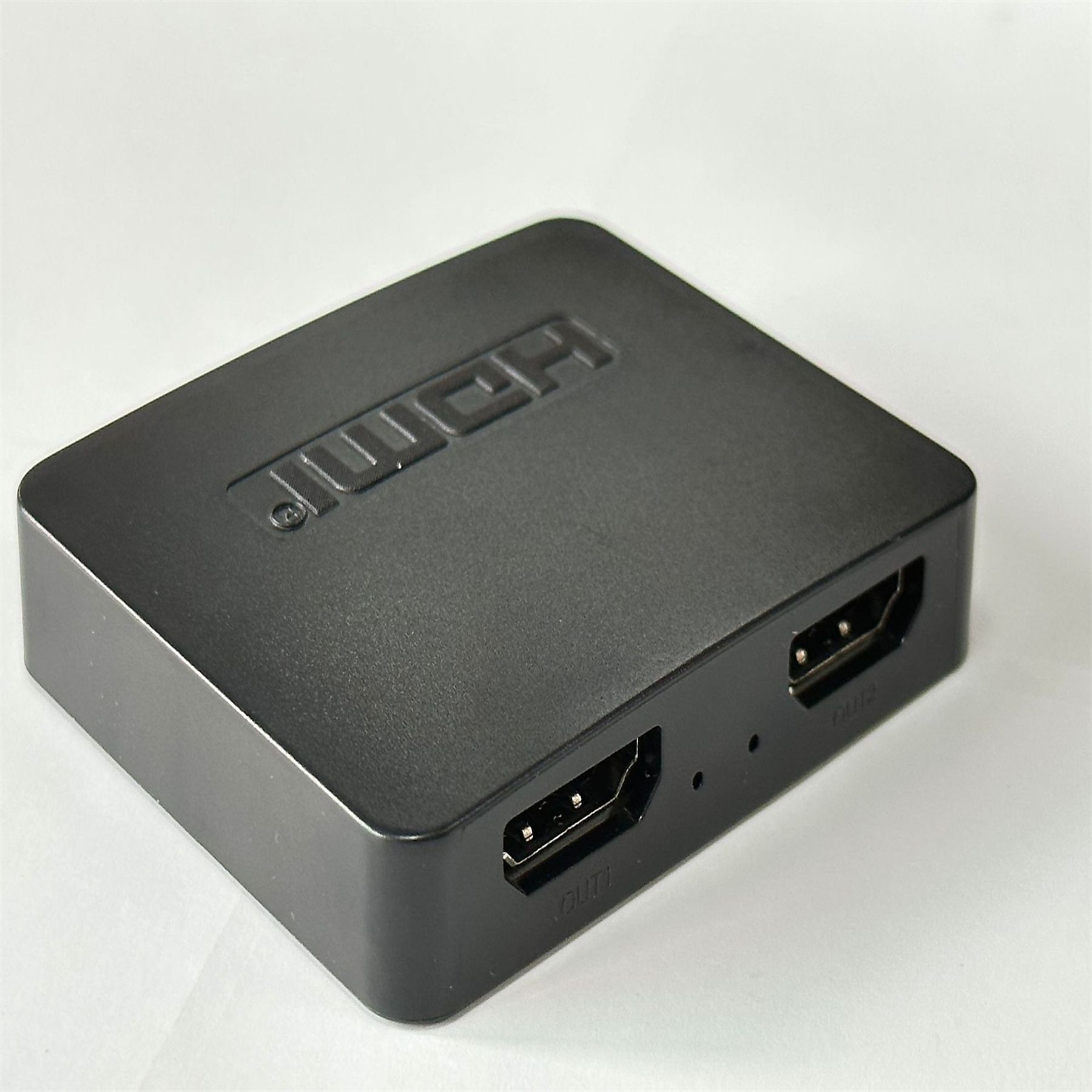 Schwarze HDMI-Box mit HDMI-Anschlüssen. Weißer Hintergrund.