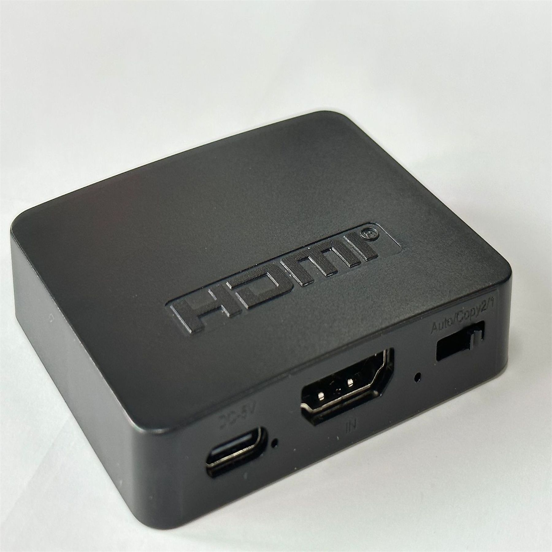Schwarze HDMI-Box mit HDMI und anderen Anschlüssen. Weißer Hintergrund.