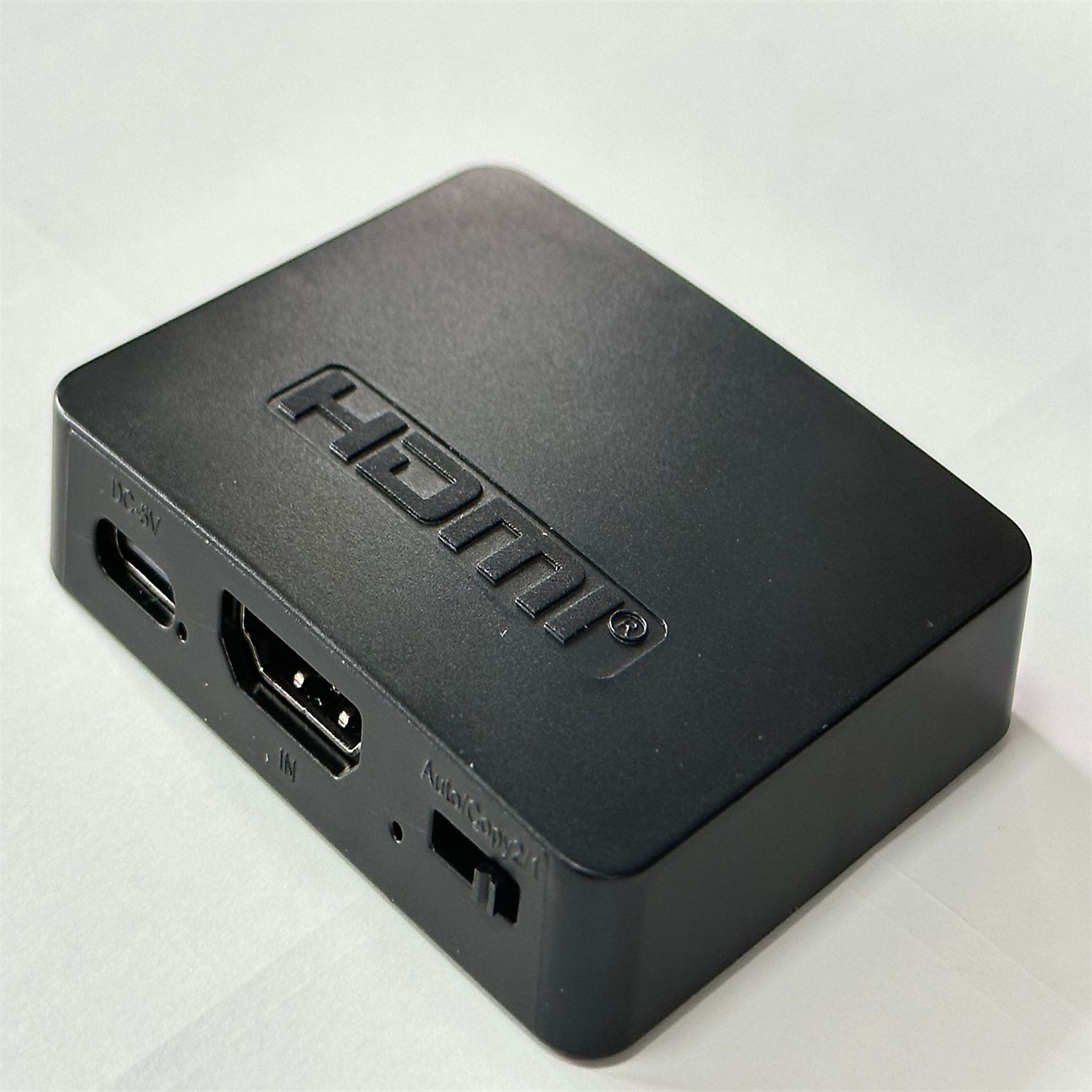 Schwarze HDMI-Box mit Anschlüssen. Weißer Hintergrund.