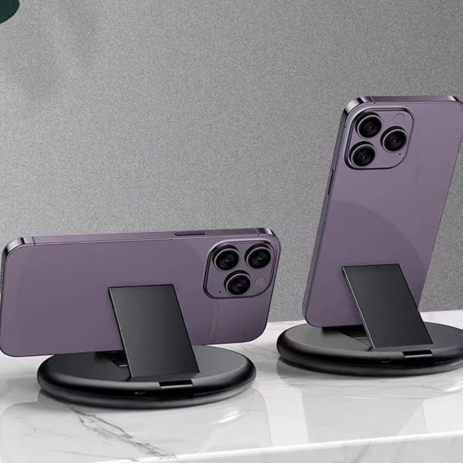 Zwei lila Telefone auf Ständern. Beide Telefone sind angewinkelt und zeigen die Rückseite mit Kameras.