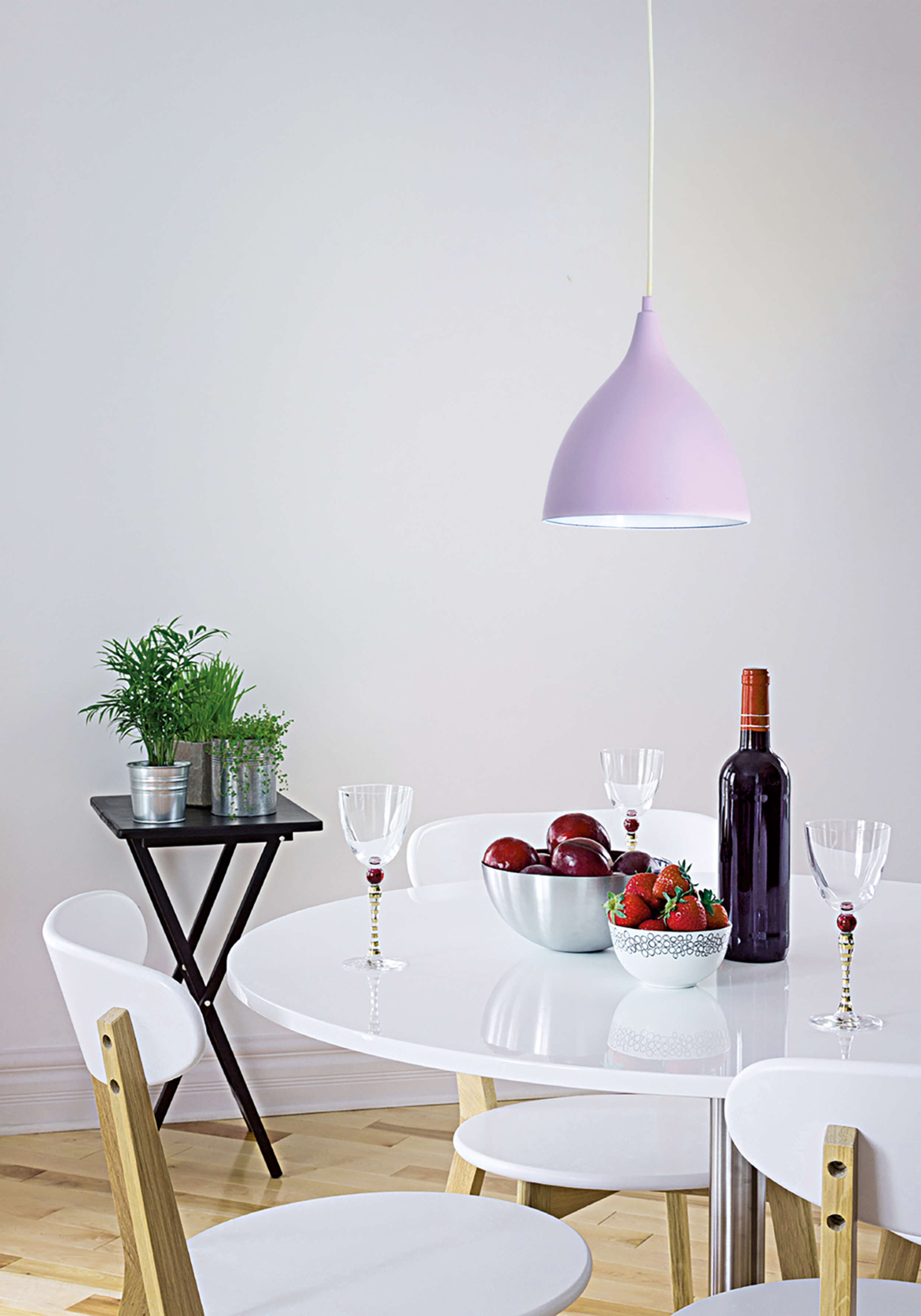 Esszimmer-Szene mit Pendelleuchte, Tisch, Stühlen und Dekoration.