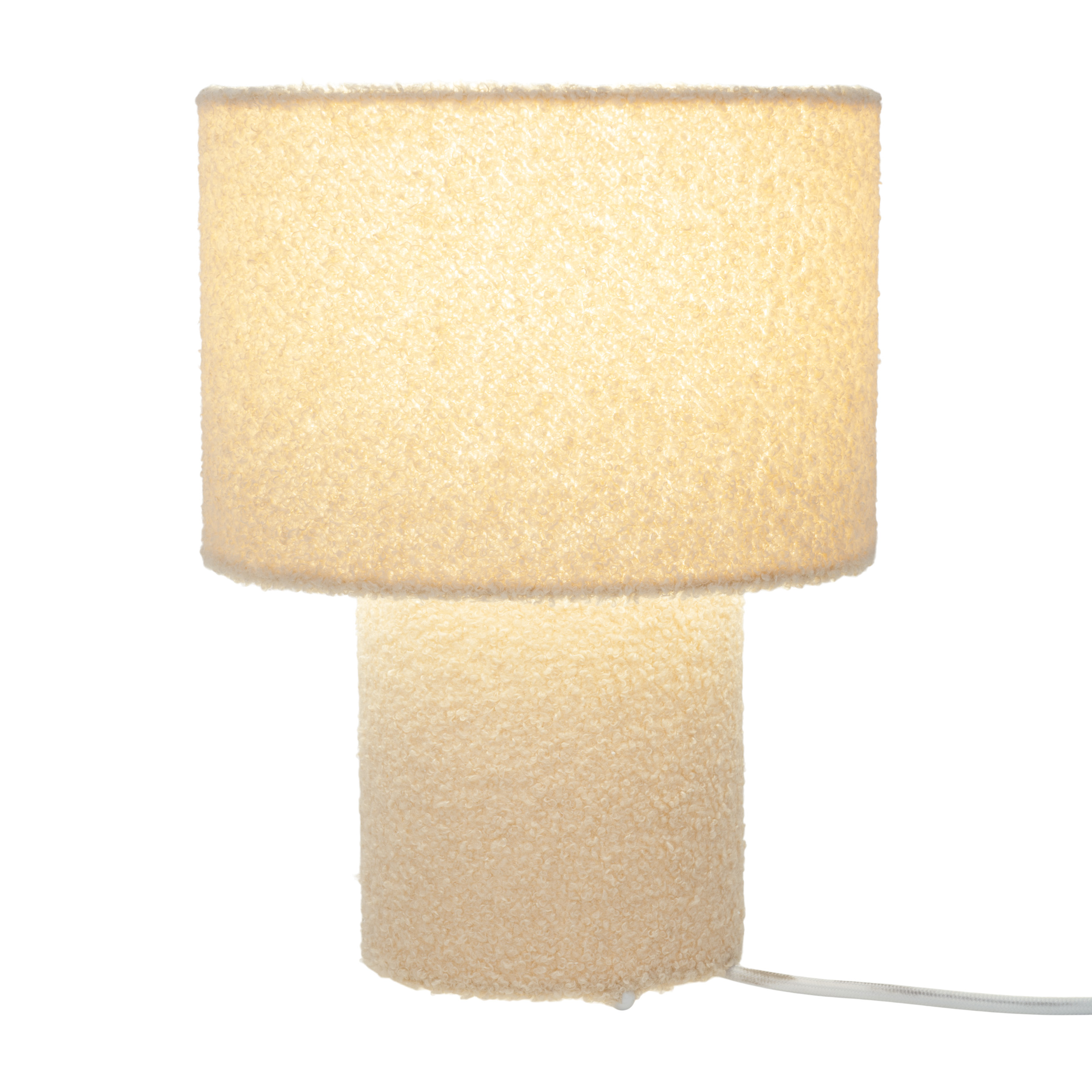 Cremefarbene Tischlampe mit zylindrischem Sockel und Lampenschirm, beleuchtet, auf weißem Hintergrund.