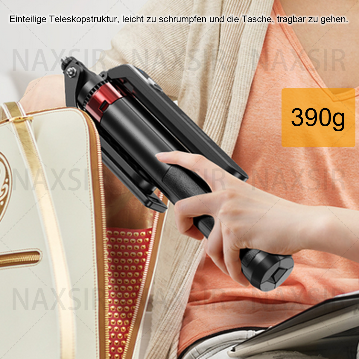 Die Hand einer Person hält einen gefalteten Selfie-Stick, und eine Tasche im Hintergrund, 390g-Etikett.