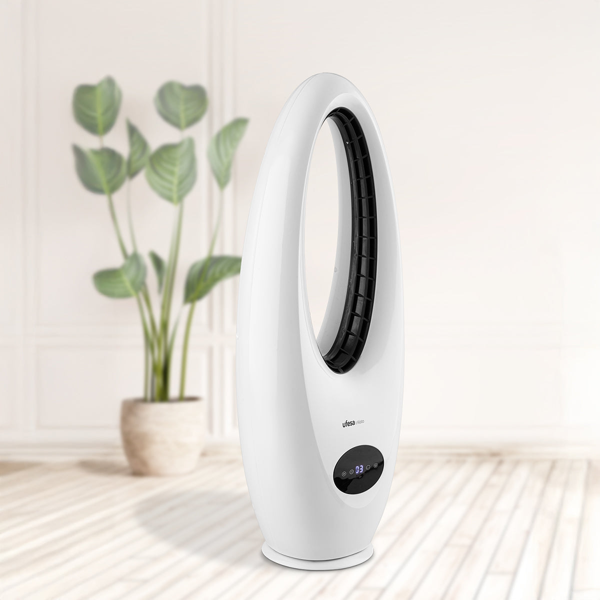 Biały owalny wentylator z cyfrowym wyświetlaczem, w ustawieniu pokoju z rośliną.