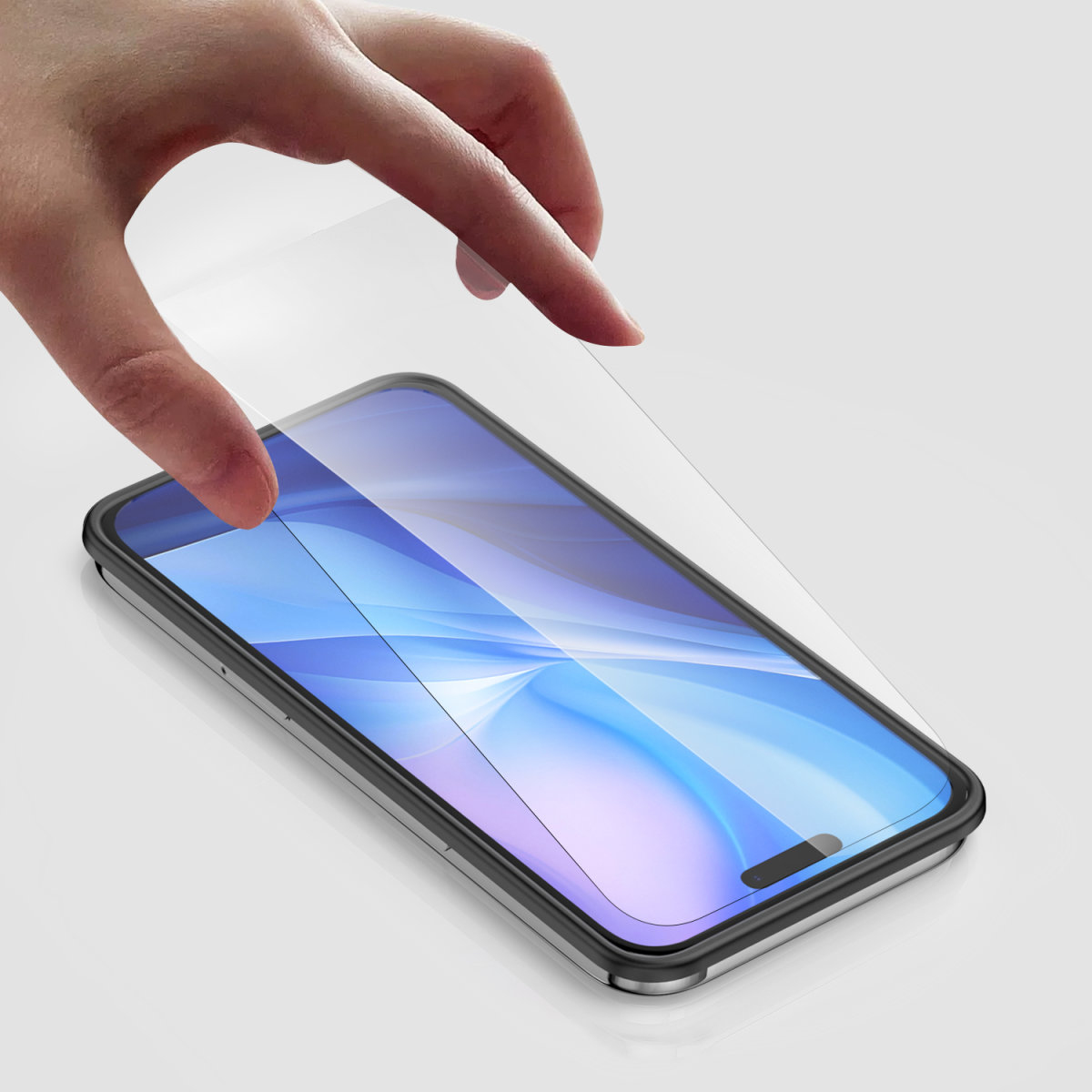 Mano che posiziona una protezione schermo su un telefono. Sfondo bianco.