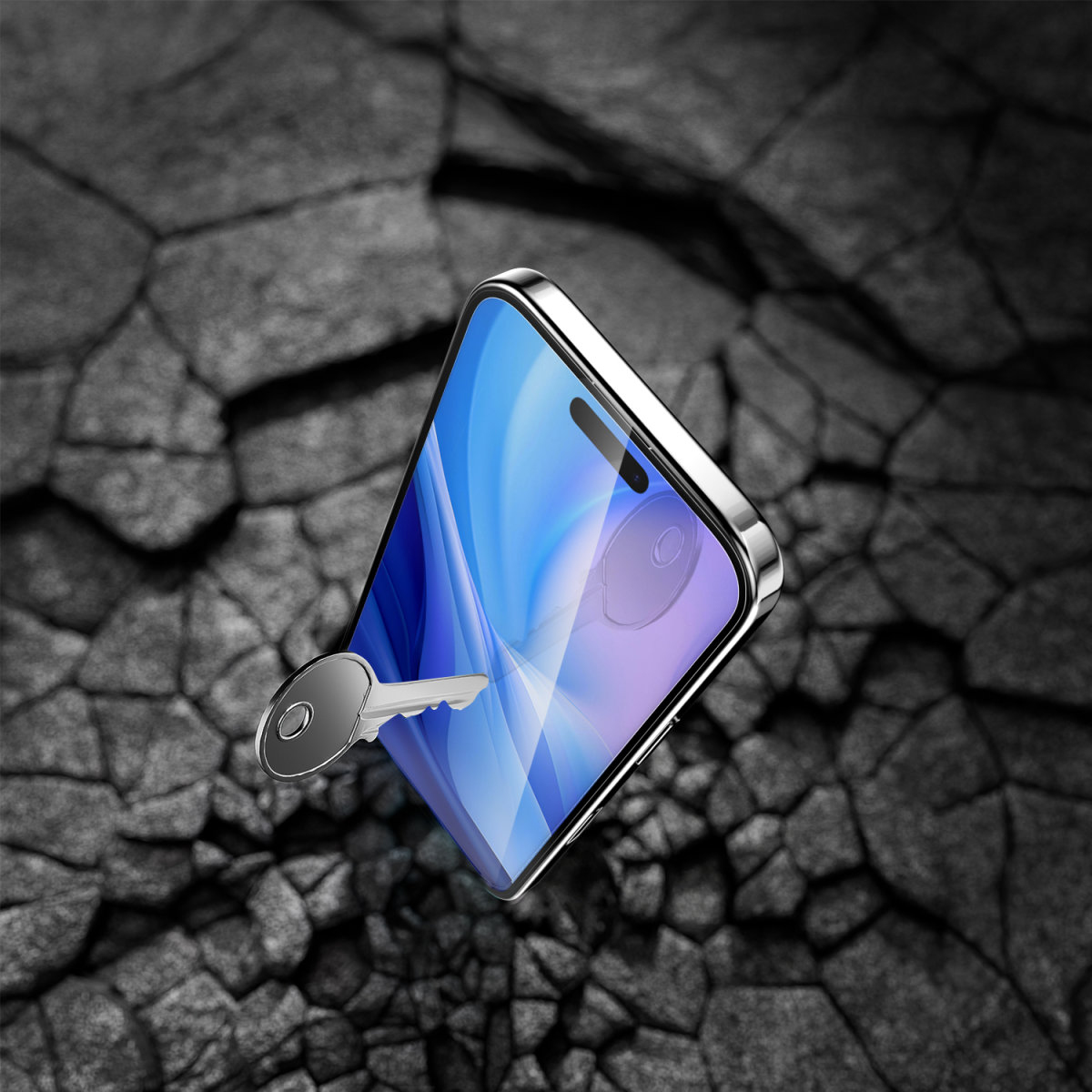 Un telefono con protezione schermo, una chiave sull'asfalto crepato.