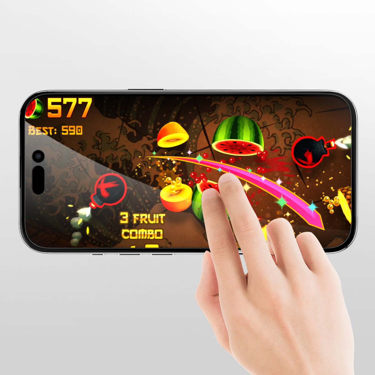 Una mano tocca un telefono con una protezione per lo schermo. Sullo schermo c'è un gioco per cellulare.