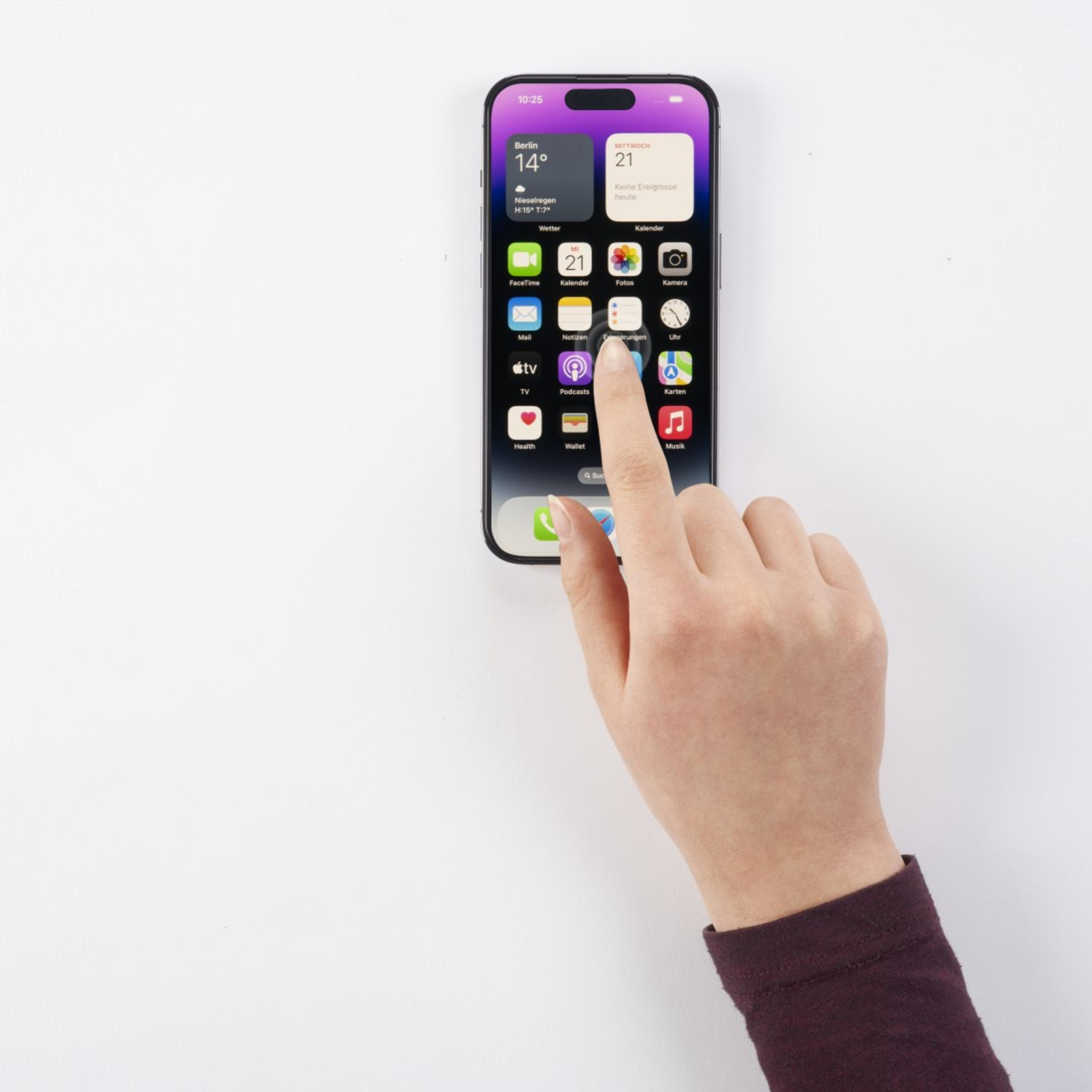 Ręka dotykająca ekranu telefonu, wyświetlającego interfejs z wieloma aplikacjami.