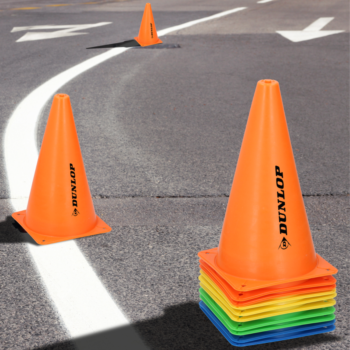 Orange traffic cones on a gray road with white lines and a single cone in the background.