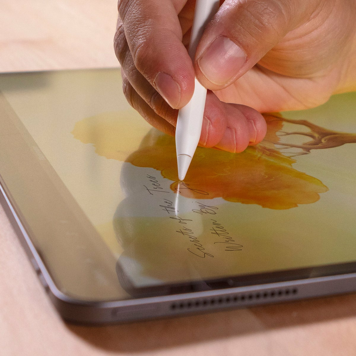 Tablet z rysikiem. Ręka trzymająca rysik pisze na tablecie.