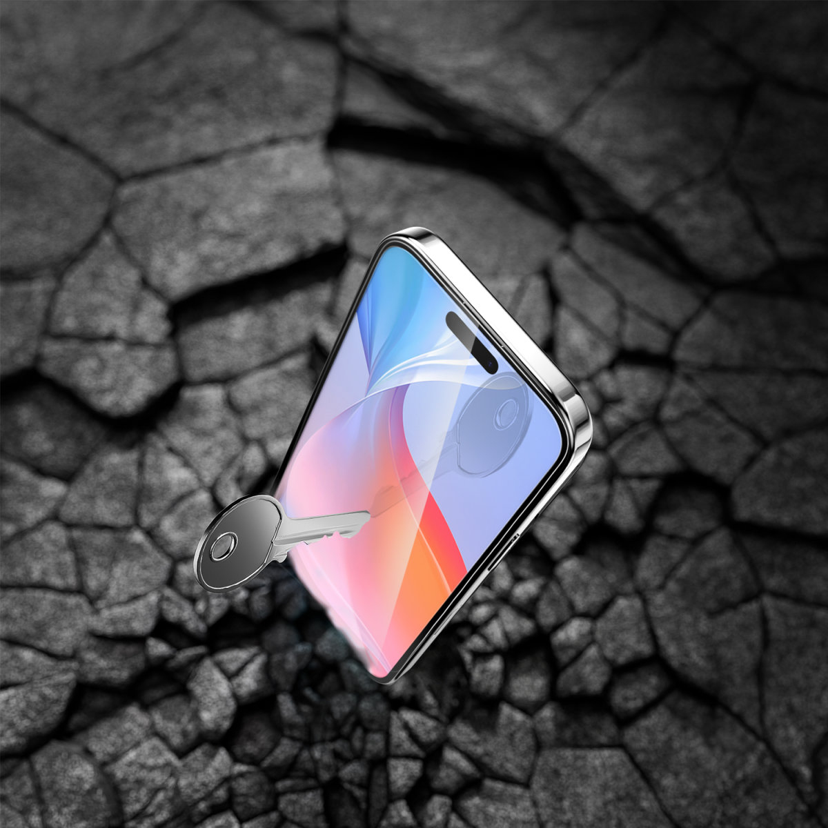 Telefon z ochraniaczem ekranu, uderzany kluczem. Scena na popękanej powierzchni.