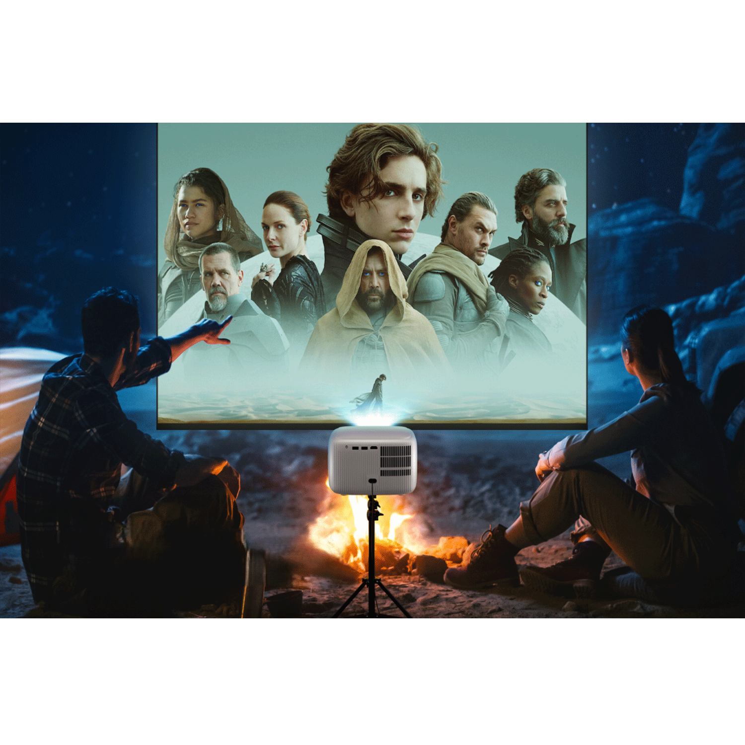 Un proiettore mostra un film su uno schermo. Due persone guardano il film, sedute. La scena è all'aperto di notte.
