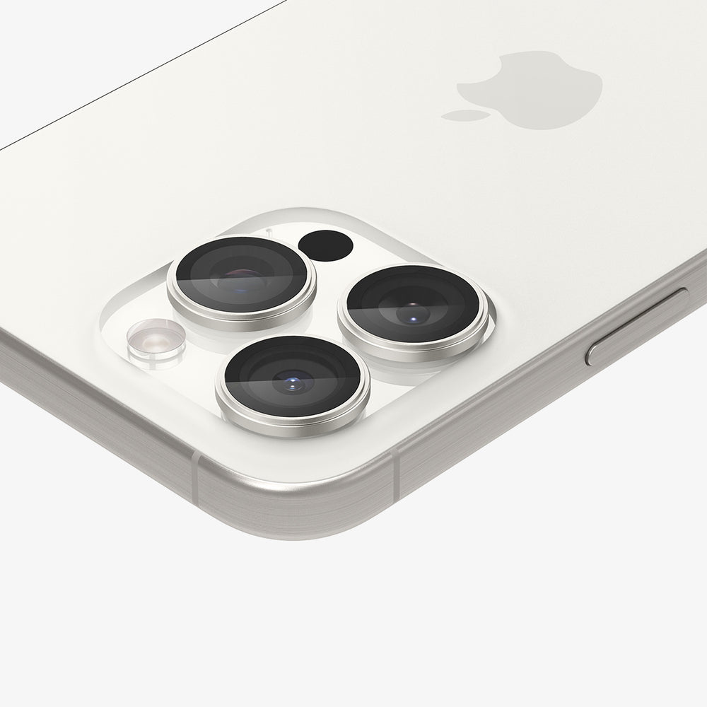 Zbliżenie obiektywów aparatu srebrnego iPhone'a. Proste tło, telefon pod kątem.