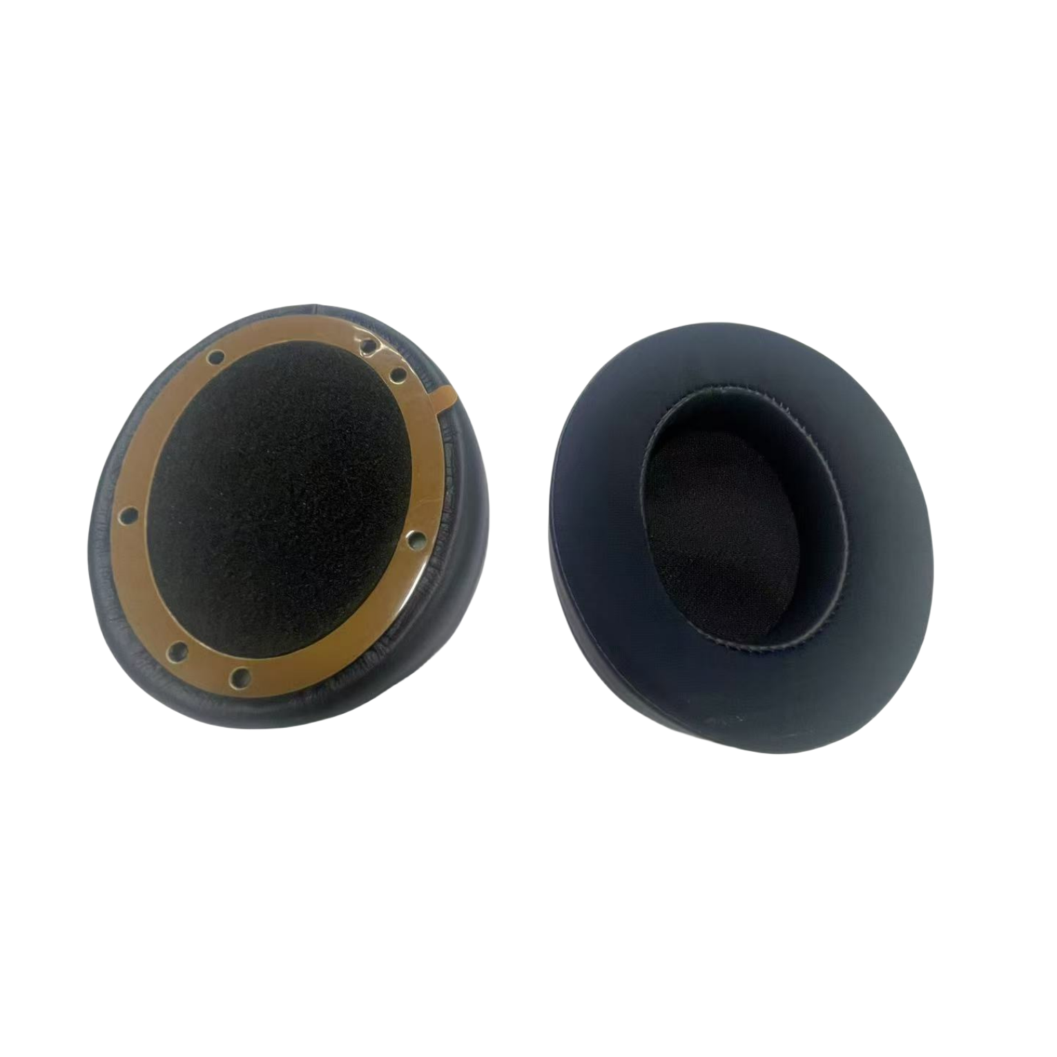 Cuscinetti auricolari per cuffie. Neri, circolari, materiale similpelle. Uno con anello dorato.