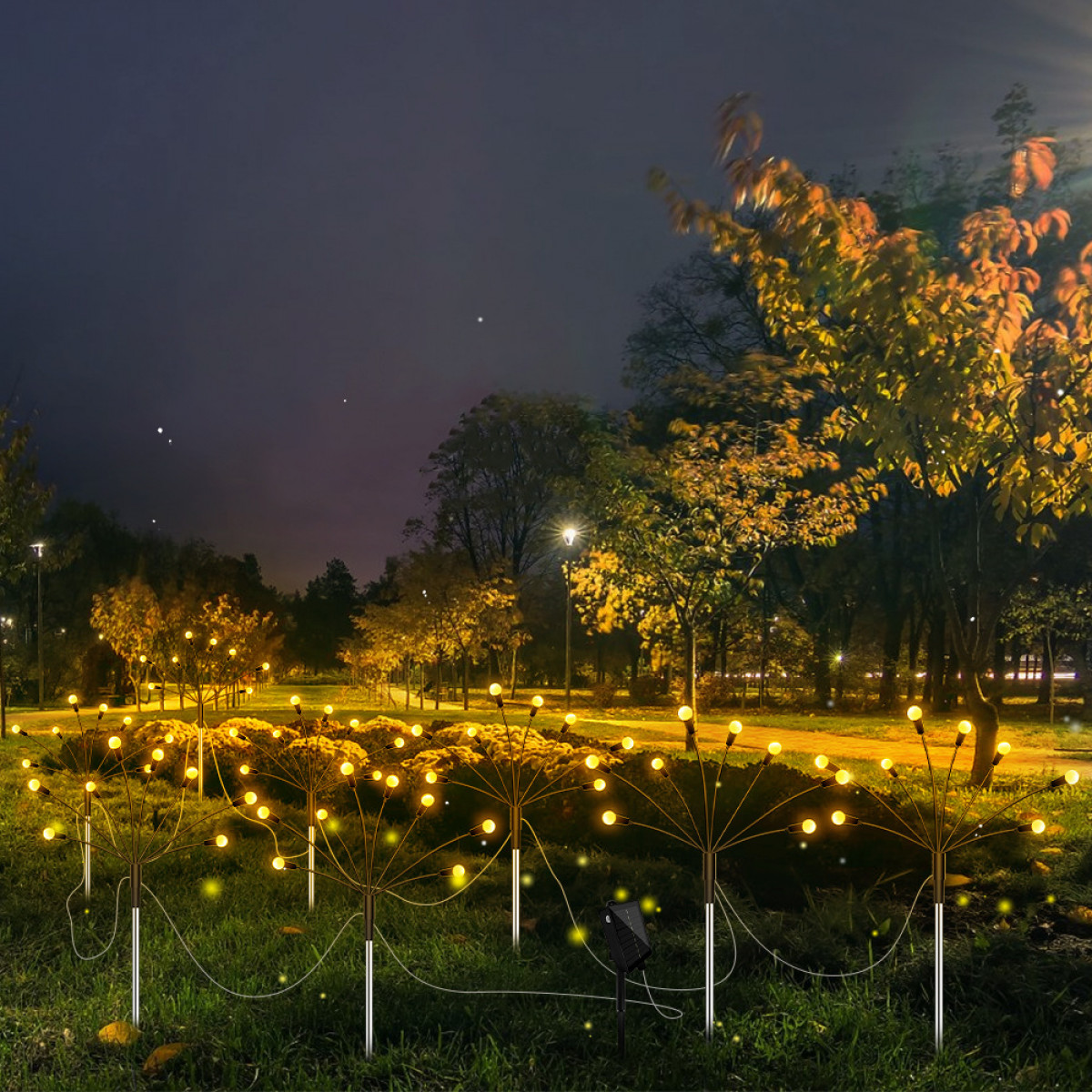 Nocna scena z lampami solarnymi w parku, oświetlająca ścieżkę i drzewa.
