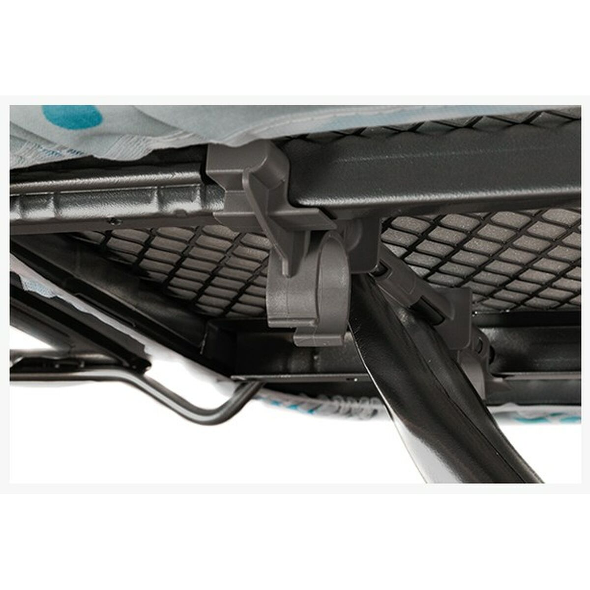 Zbliżenie szarych klipsów na metalowej ramie podtrzymującej tkaninę.