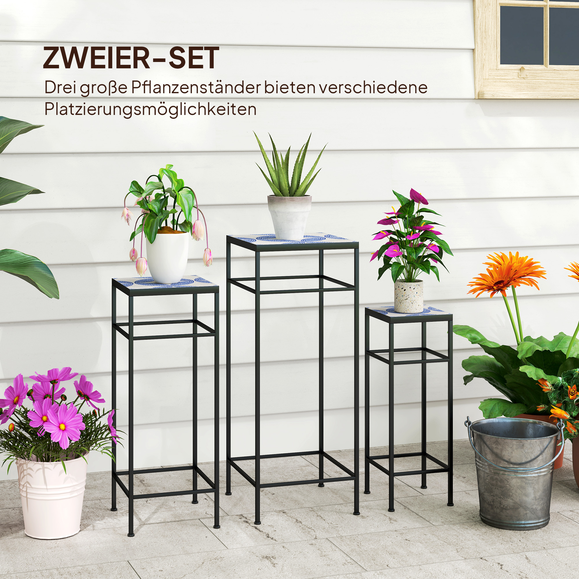 Drei Pflanzenständer mit Pflanzen auf einer Terrasse. Jeder hat eine blau-weiß geflieste Oberfläche, mit verschiedenen Pflanzen.