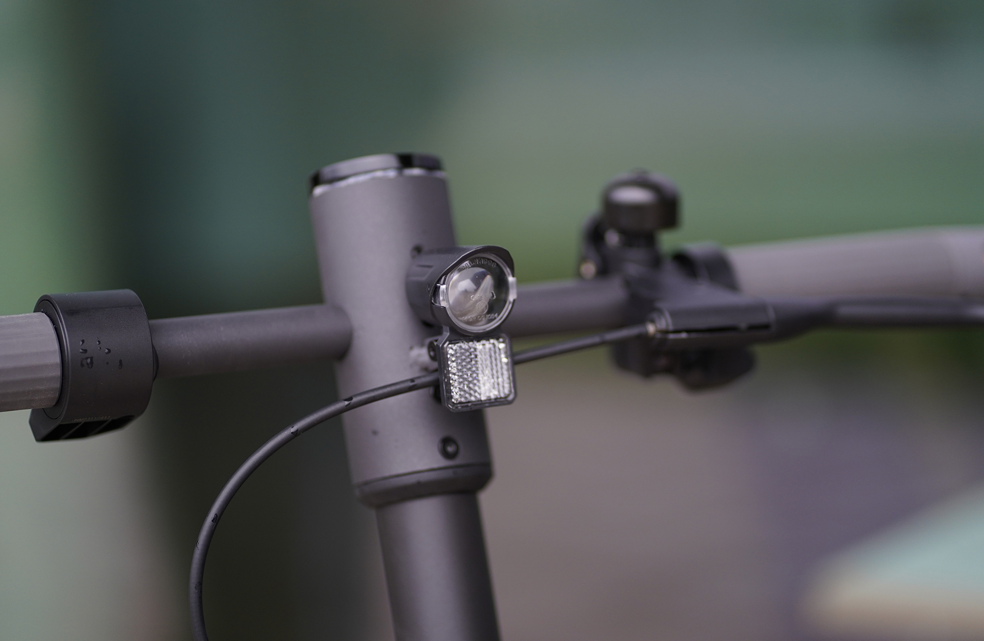 Nahaufnahme des Frontlichts eines Elektrorollers und anderer Details am Lenker.