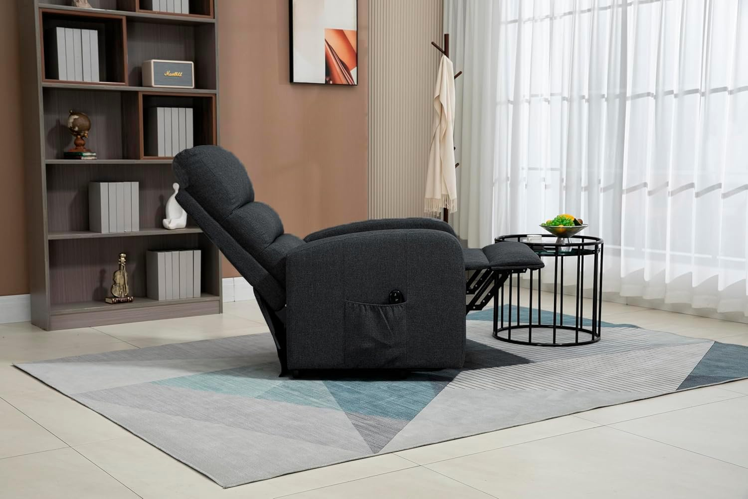 Sillón reclinable gris oscuro con reposapiés extendido, en un salón.