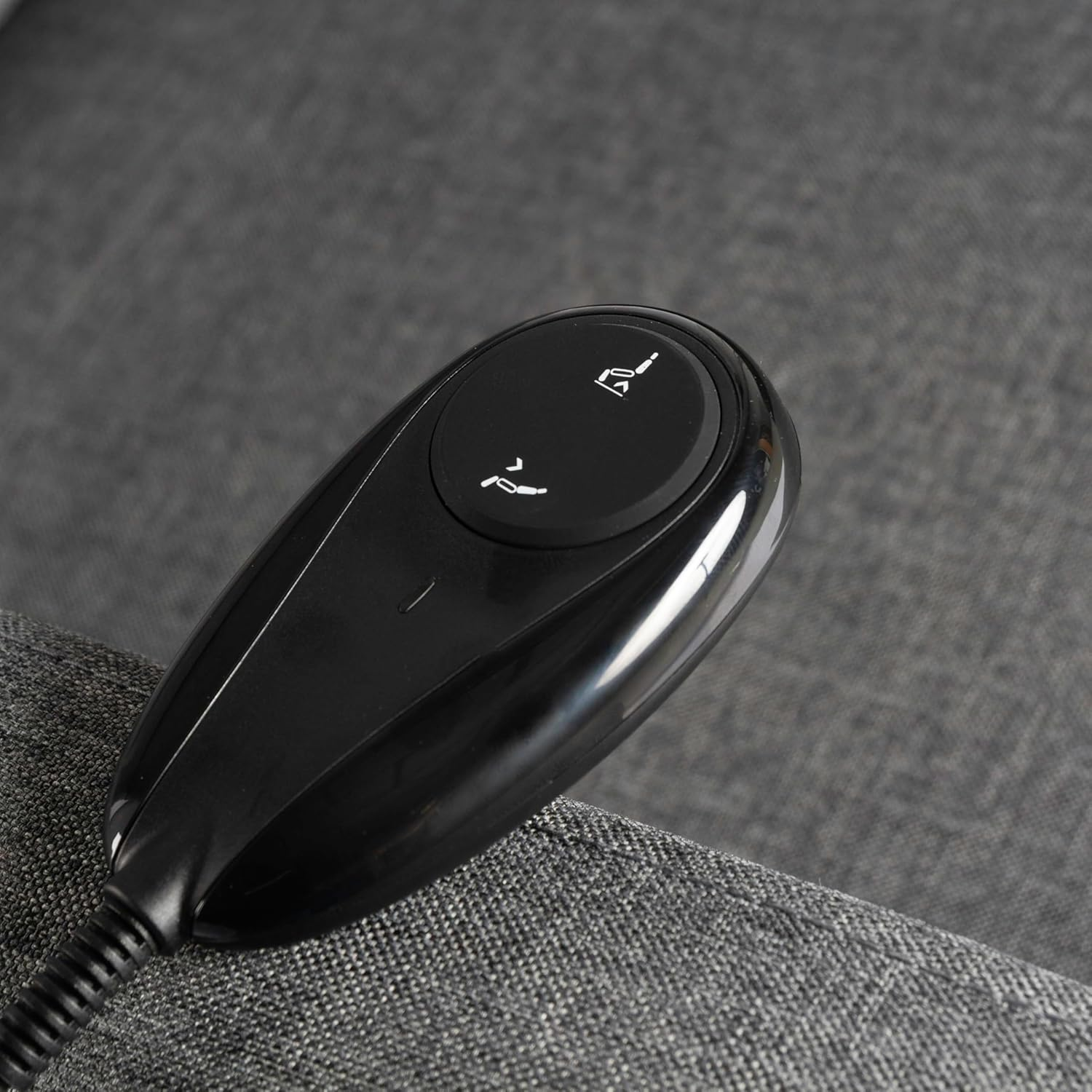 Primer plano de un mando a distancia negro con flechas, para ajustar un sillón reclinable.
