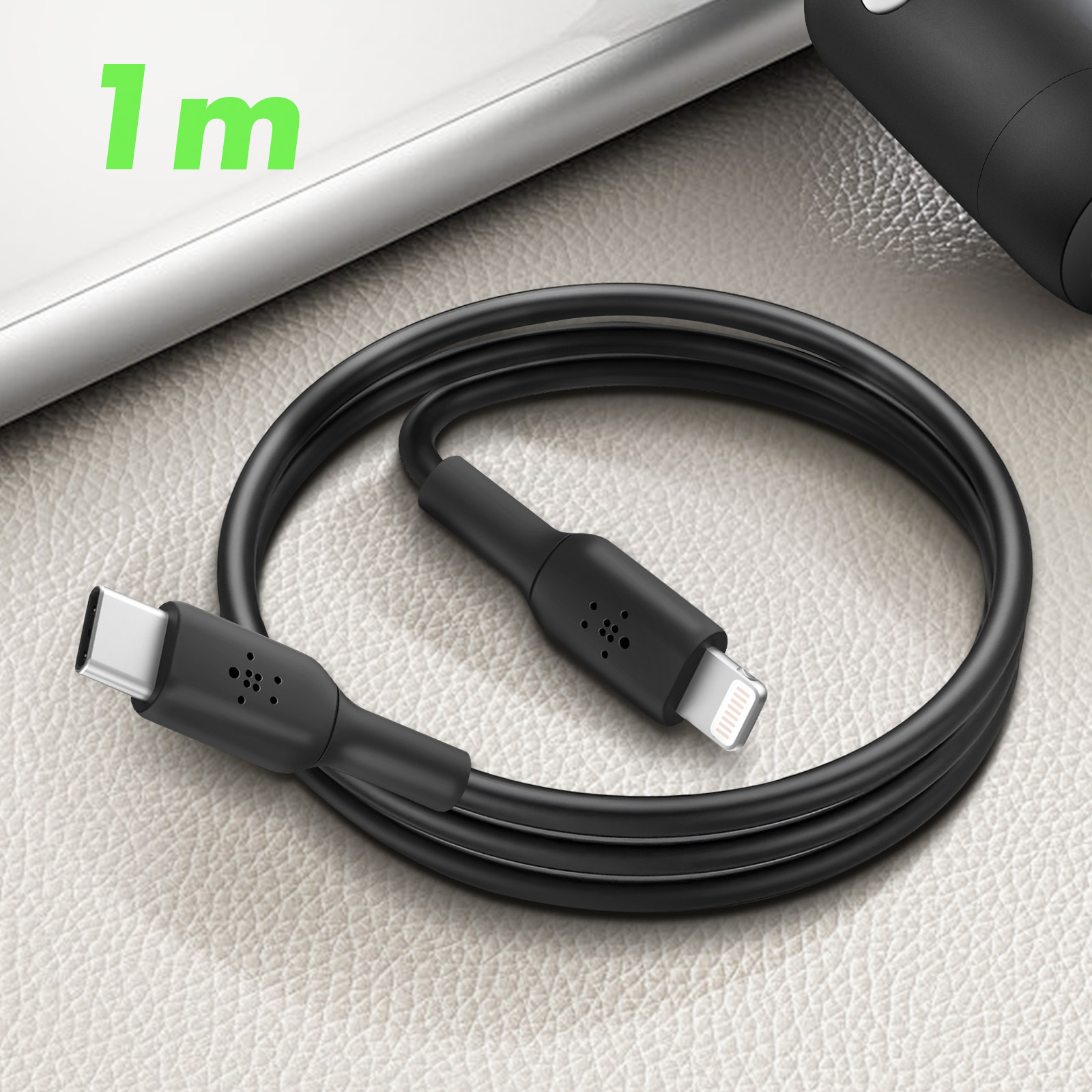 Un cavo di ricarica nero con connettori USB-C e Lightning, appoggiato su una superficie strutturata.