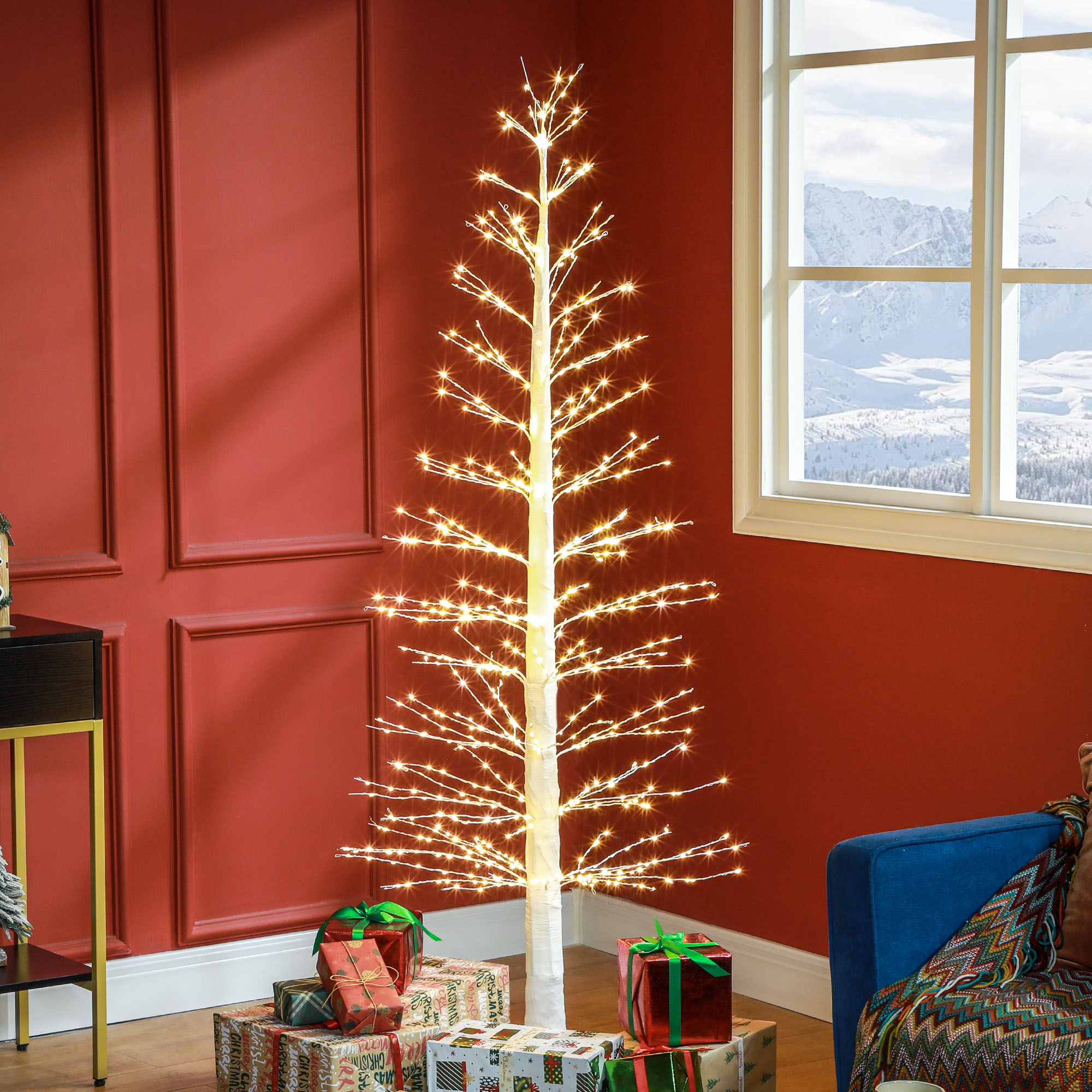 Beleuchteter Weihnachtsbaum mit Lichtern. Geschenke liegen unter dem Baum. Rote Wand im Hintergrund.