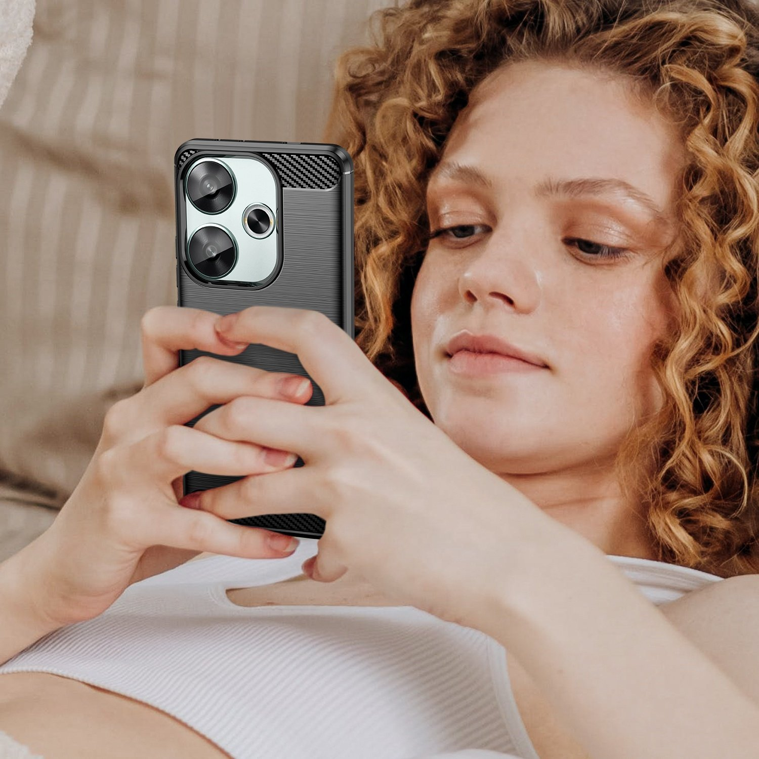 Mujer sosteniendo un teléfono en una funda negra, mostrando la pantalla, con un fondo borroso.