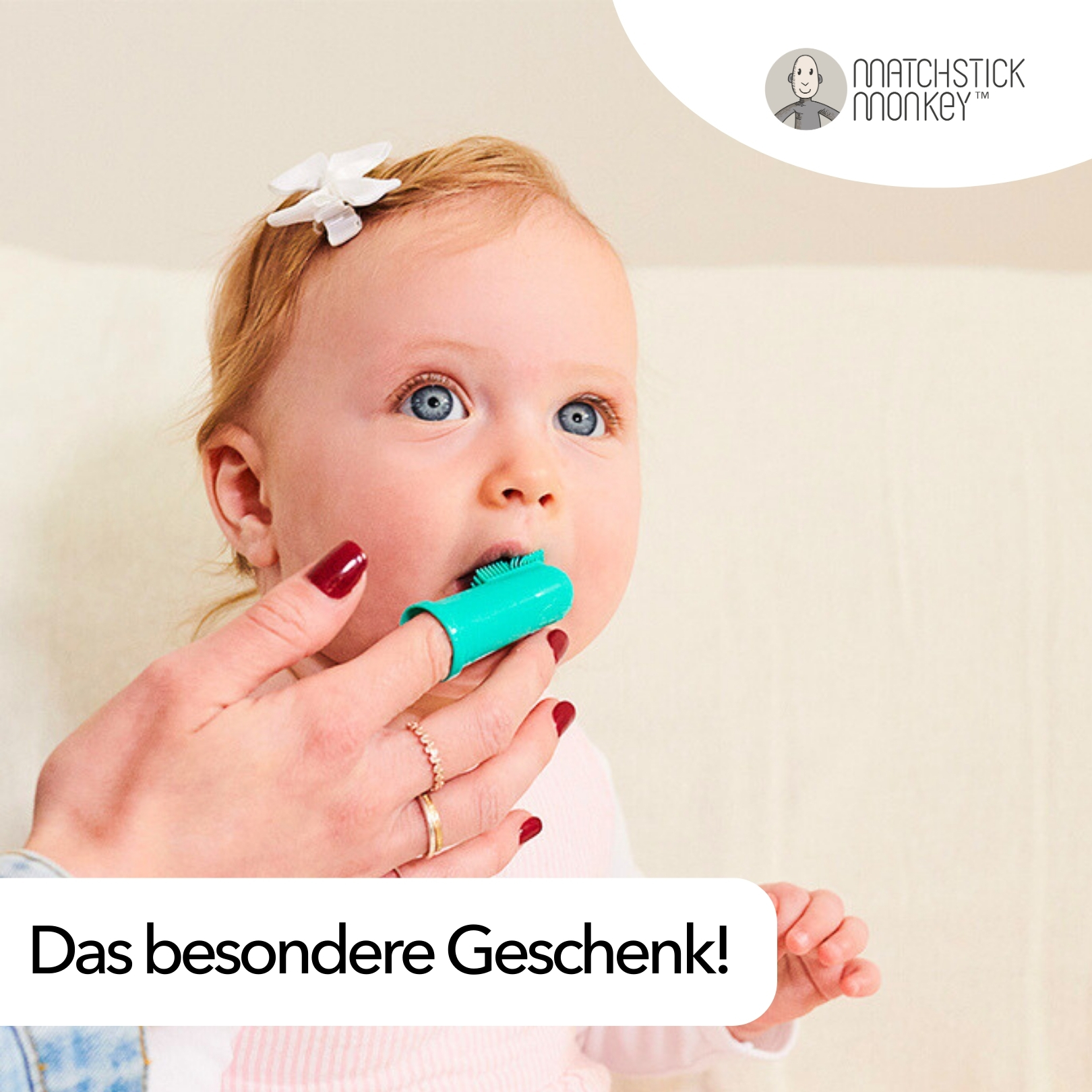 Baby mit Zahnbürste im Mund, gehalten von einer Hand. Text: Das besondere Geschenk!