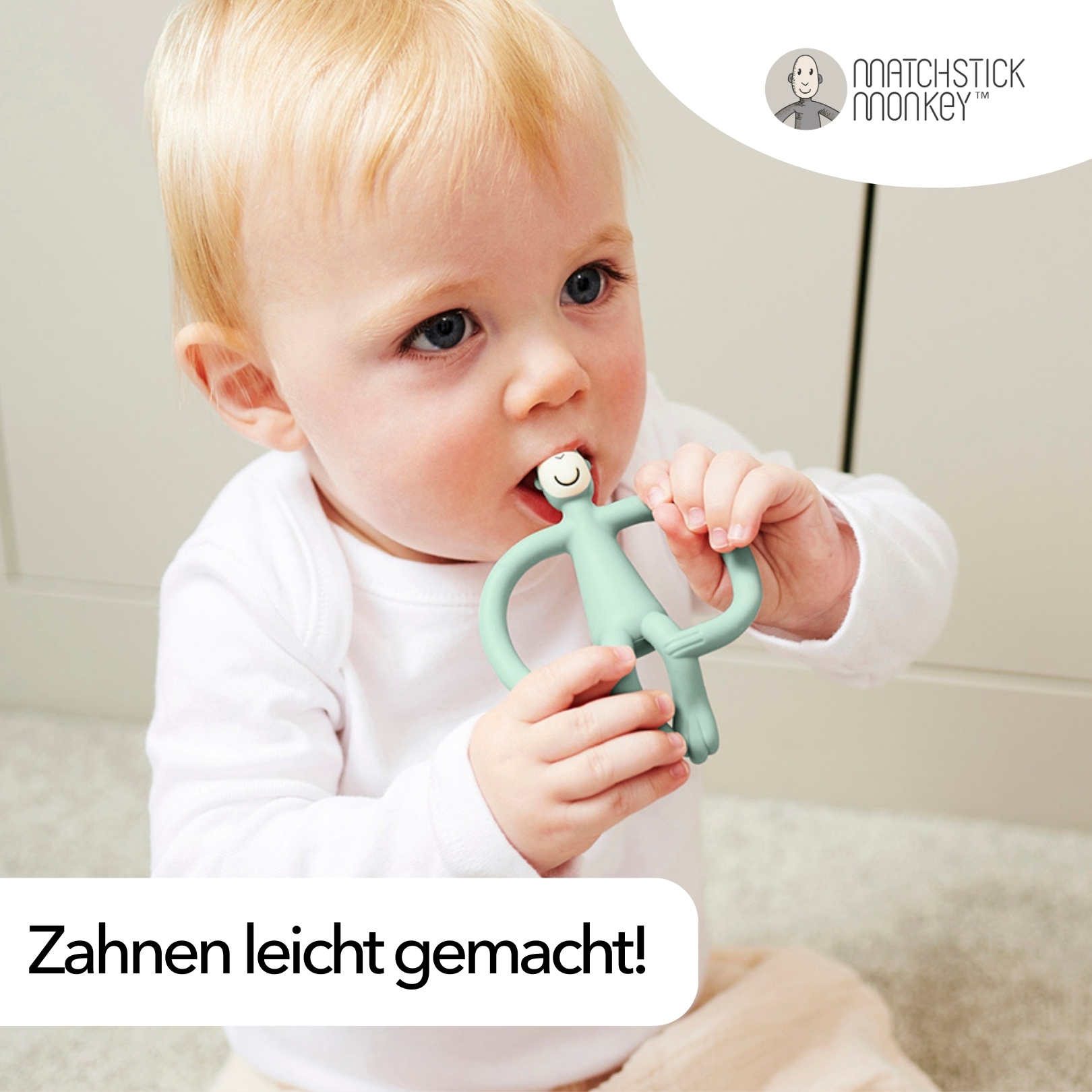 Baby kaut auf einem grünen Affen-Beißring. Text: 'Zahnen leicht gemacht!'