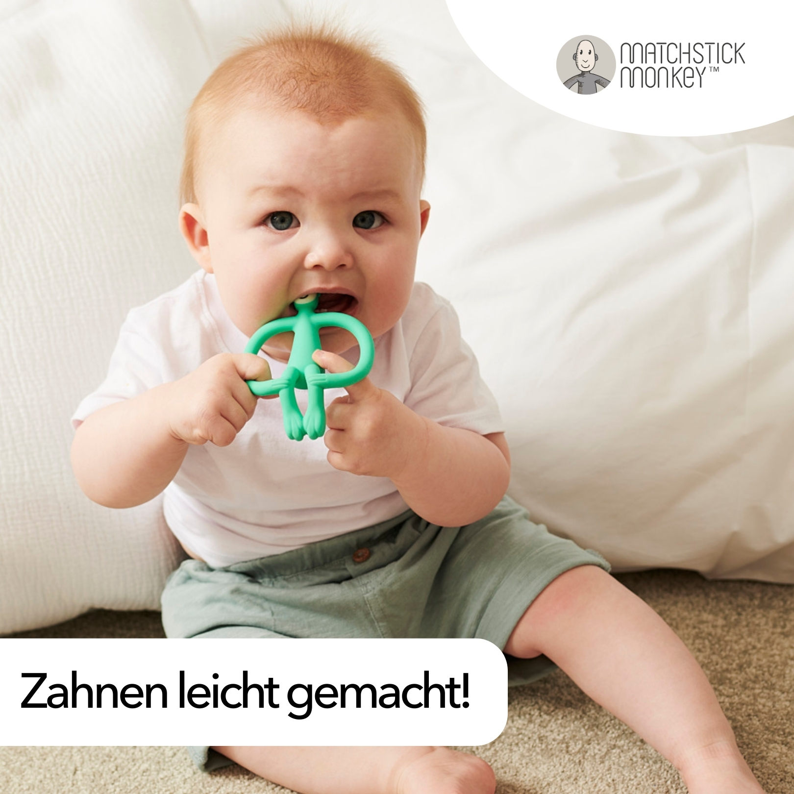 Baby beißt auf ein grünes Beißspielzeug in Form eines Affen. Weißer Hintergrund und Text 'Zahnen leicht gemacht!'